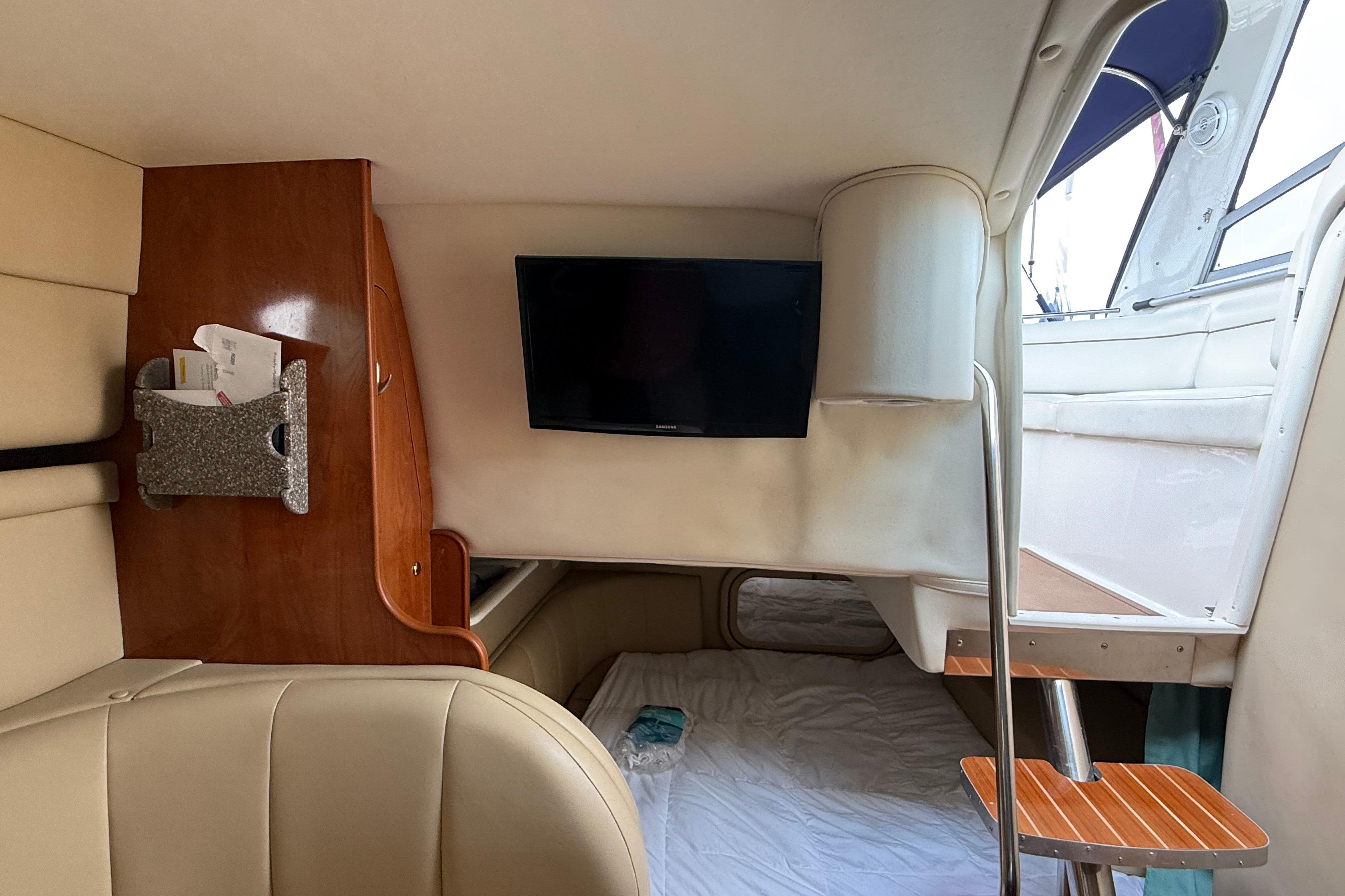 Interior cabin of a 2004 Rinker 342 boat with TV and seating area.