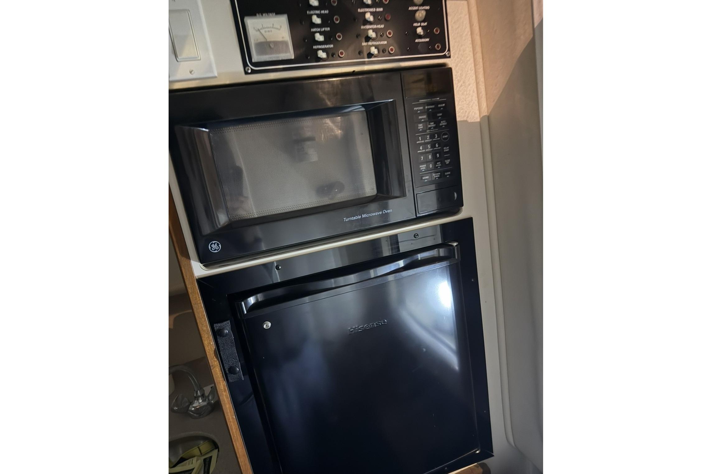 Microwave and mini fridge in 2000 Pursuit 3070 Offshore Center Console boat kitchen.