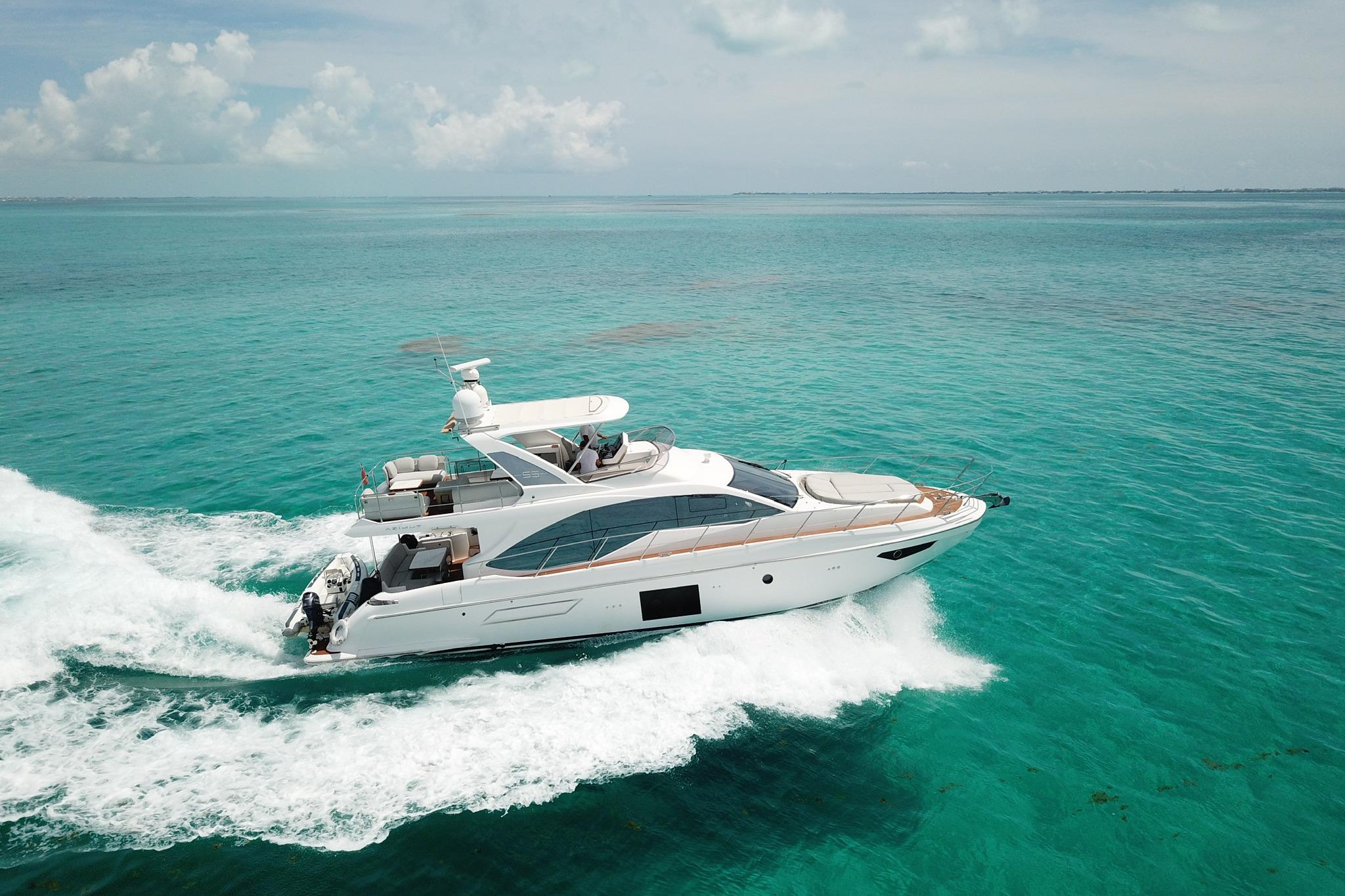 2021 Azimut 55 yacht cruising on turquoise ocean waters under a clear sky.