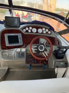 Custom Commodore 2008 boat helm with wooden steering wheel.