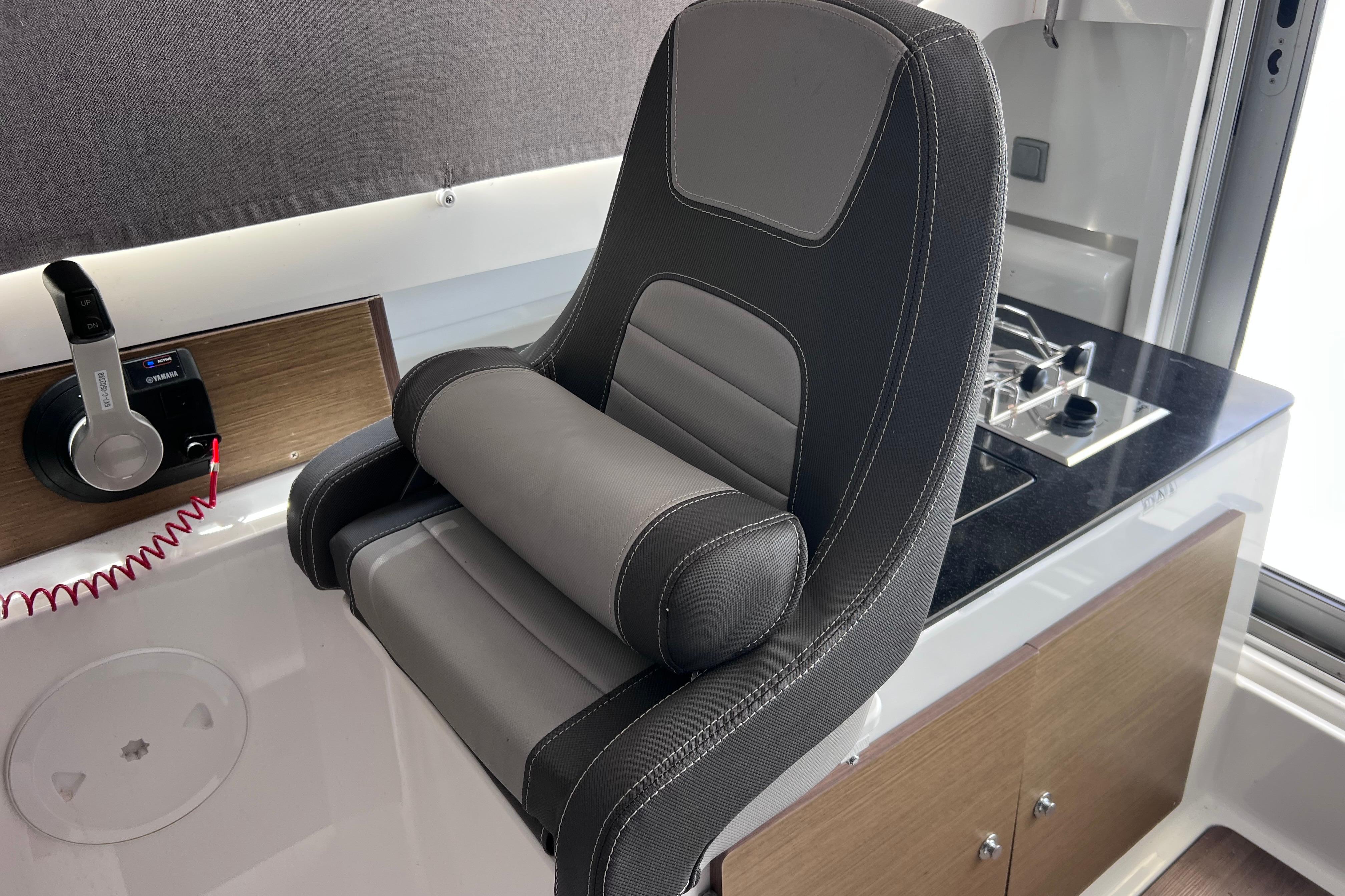 Captain's seat and control panel in 2021 Jeanneau NC Weekender 795 Series 2 boat interior.