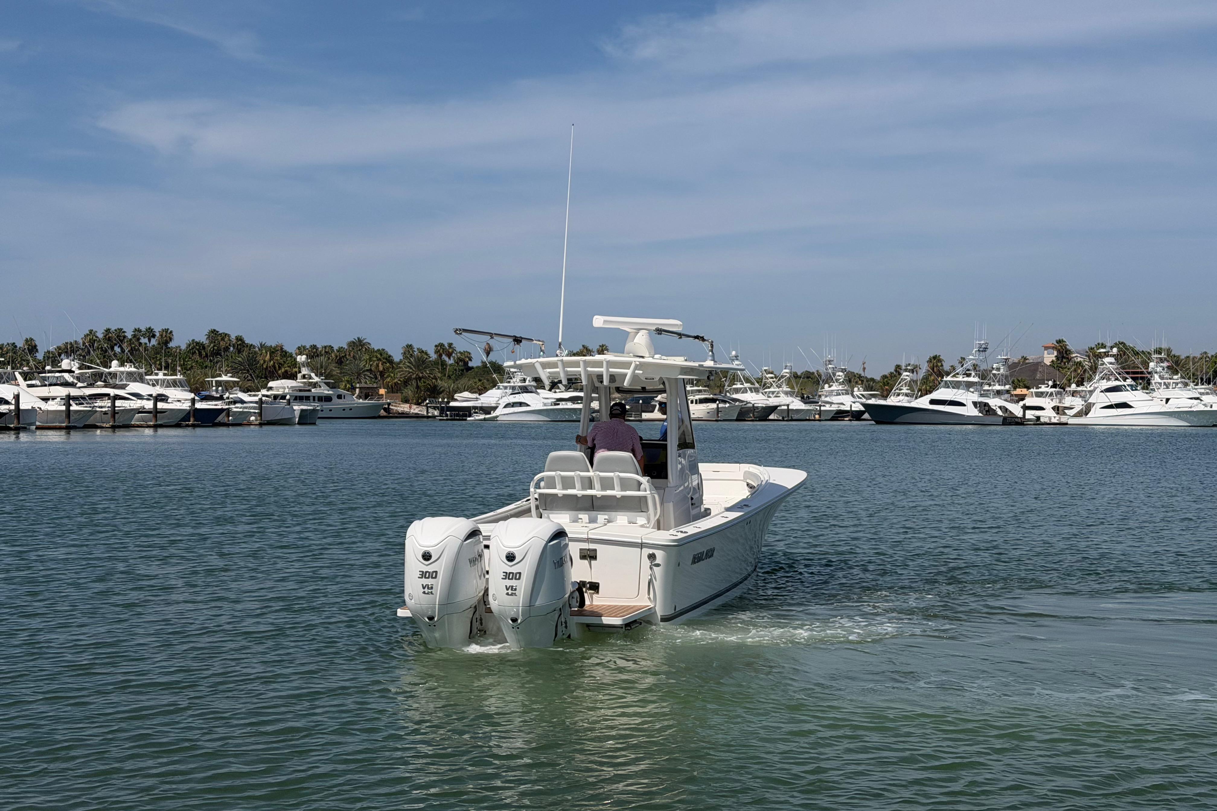 2022 Regulator 28 boat cruising in a marina with yachts in the background.