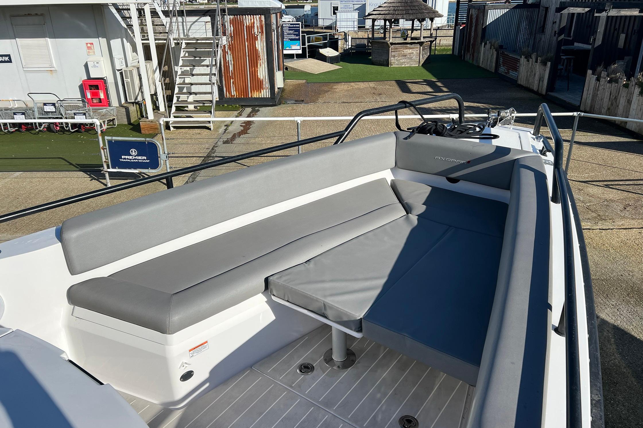 2019 Axopar 28 T-Top boat with gray seating, docked at a marina.