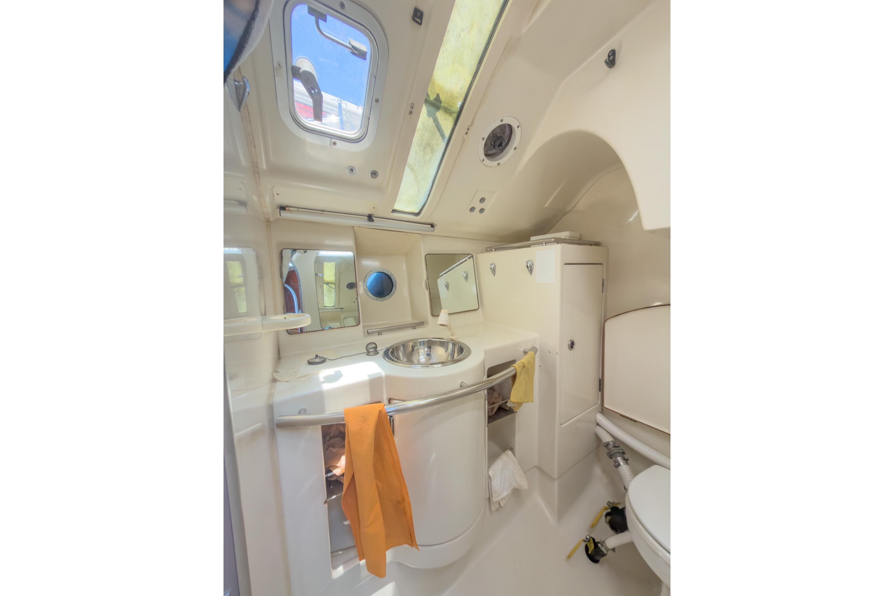 Interior of 1993 Beneteau First 38 s5 yacht bathroom with sink, mirror, and porthole.