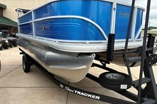 2026 Sun Tracker Party Barge 18 DLX pontoon boat on trailer, blue exterior.