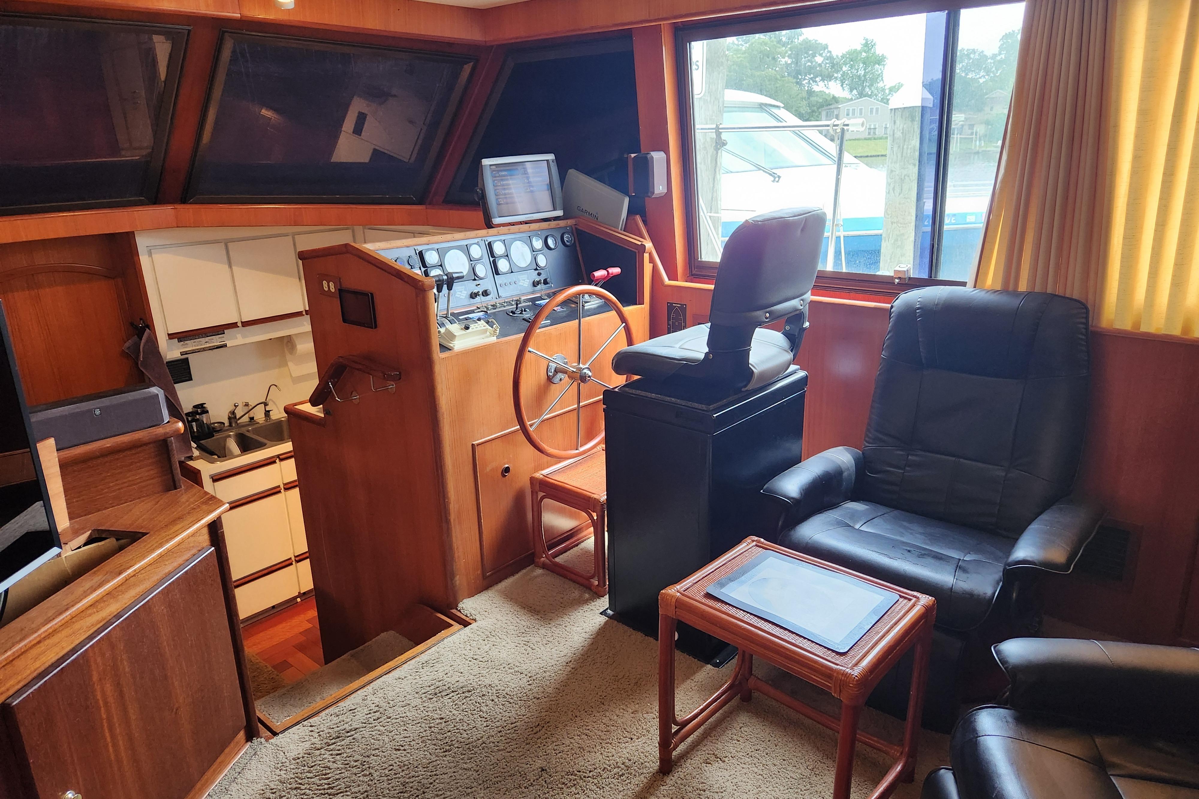 Interior of 1989 Hyatt Double Cabin Motoryacht with helm, seating, and kitchenette.