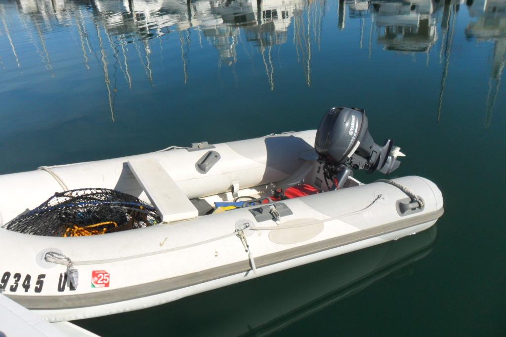 Inflatable boat with Yamaha motor docked on calm water, near Bertram 46.6 Sport Fisher.