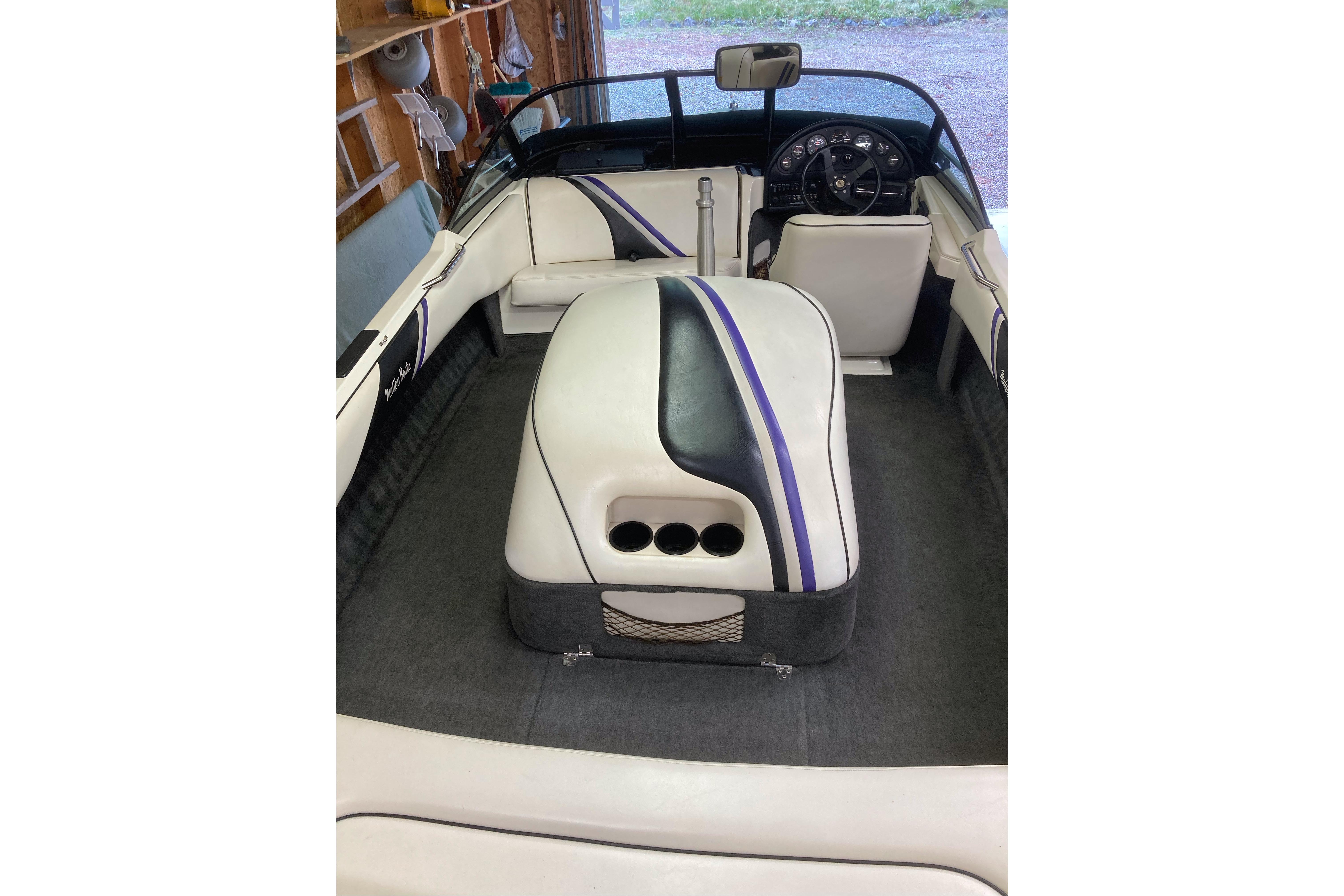 Interior of a 1996 Malibu Response boat with white and purple seating.