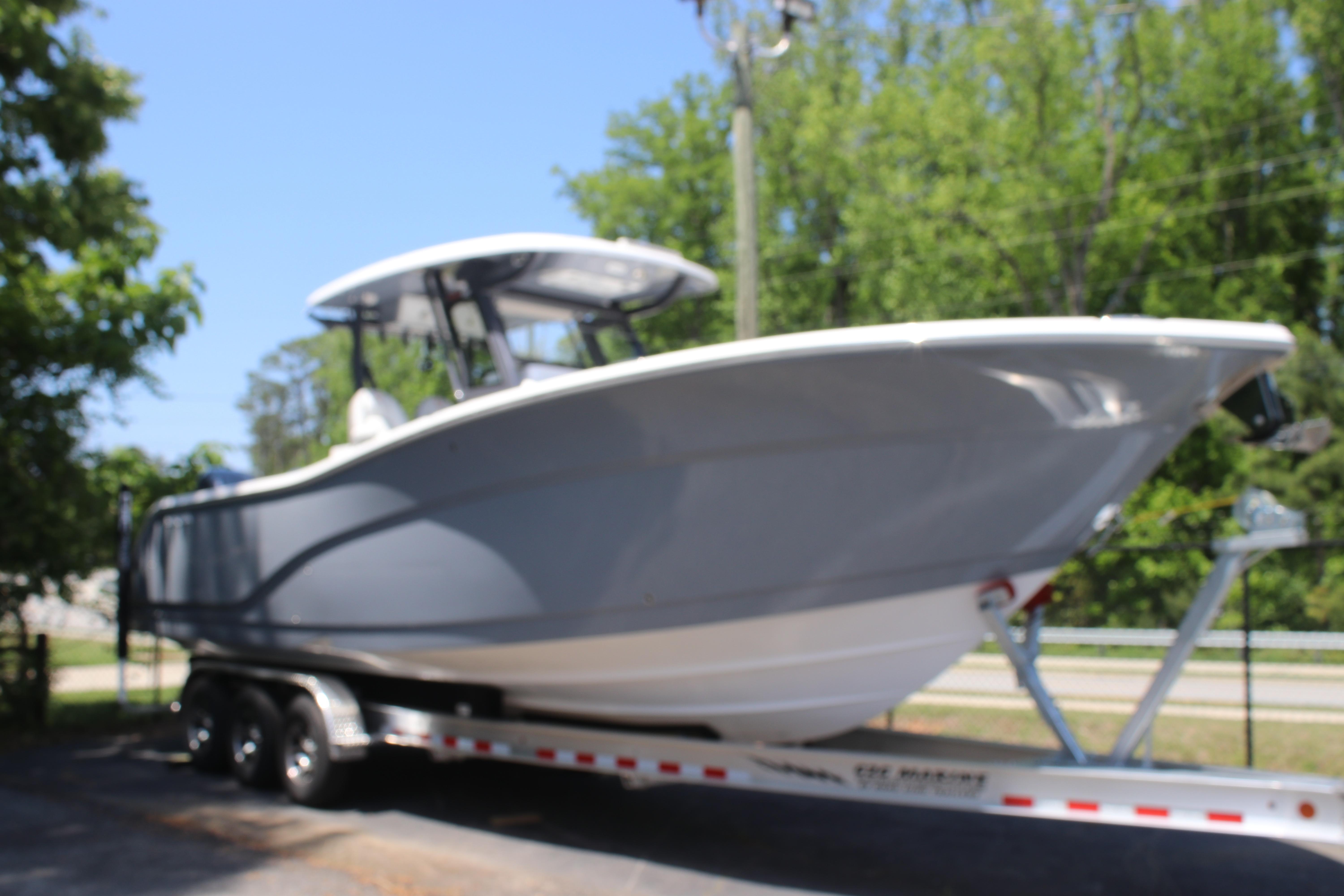 2025 Sea Fox 328 Commander boat on trailer, surrounded by trees.