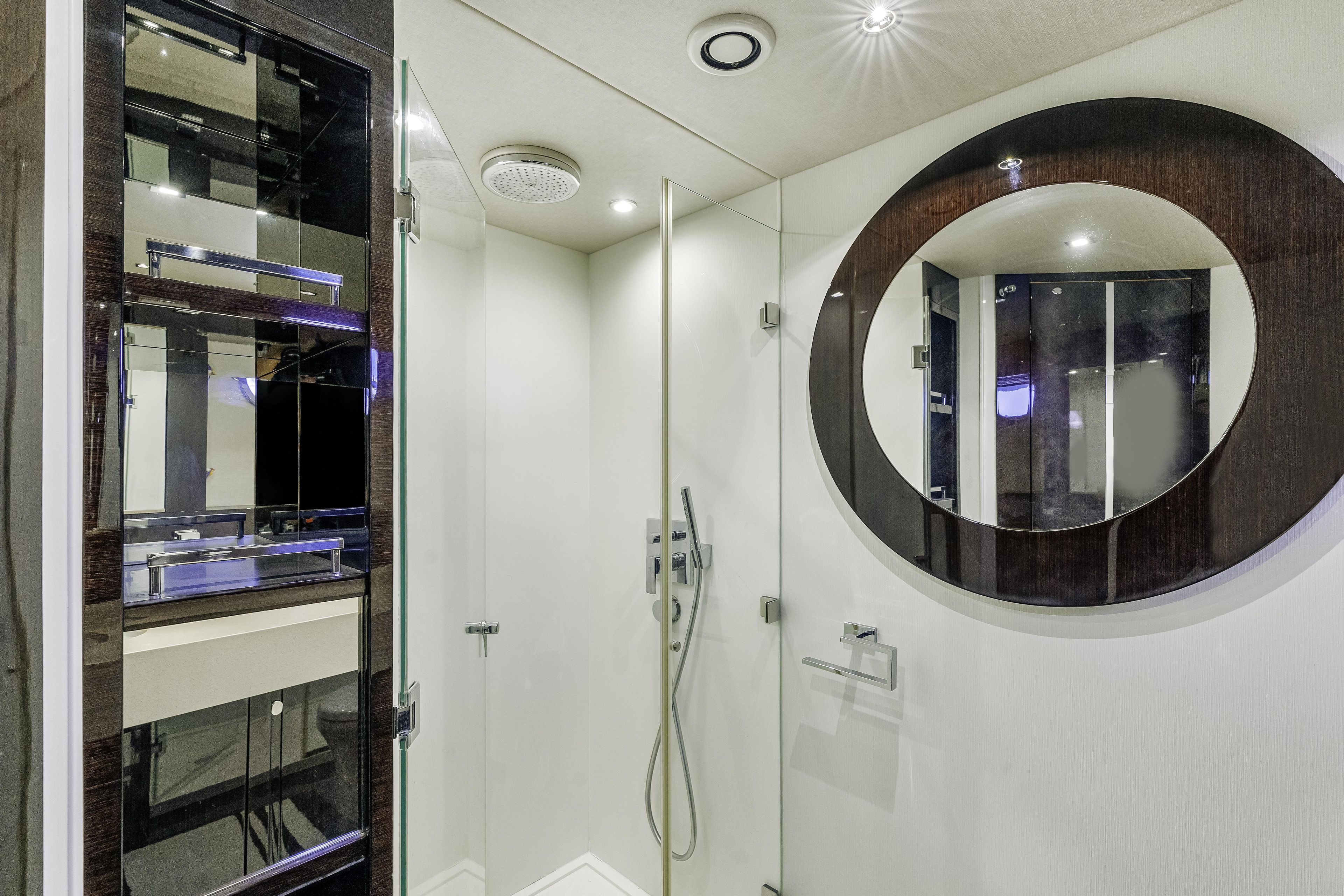 Luxurious bathroom interior of 2014 Sunseeker 68 Sport Yacht with modern fixtures and round mirror.