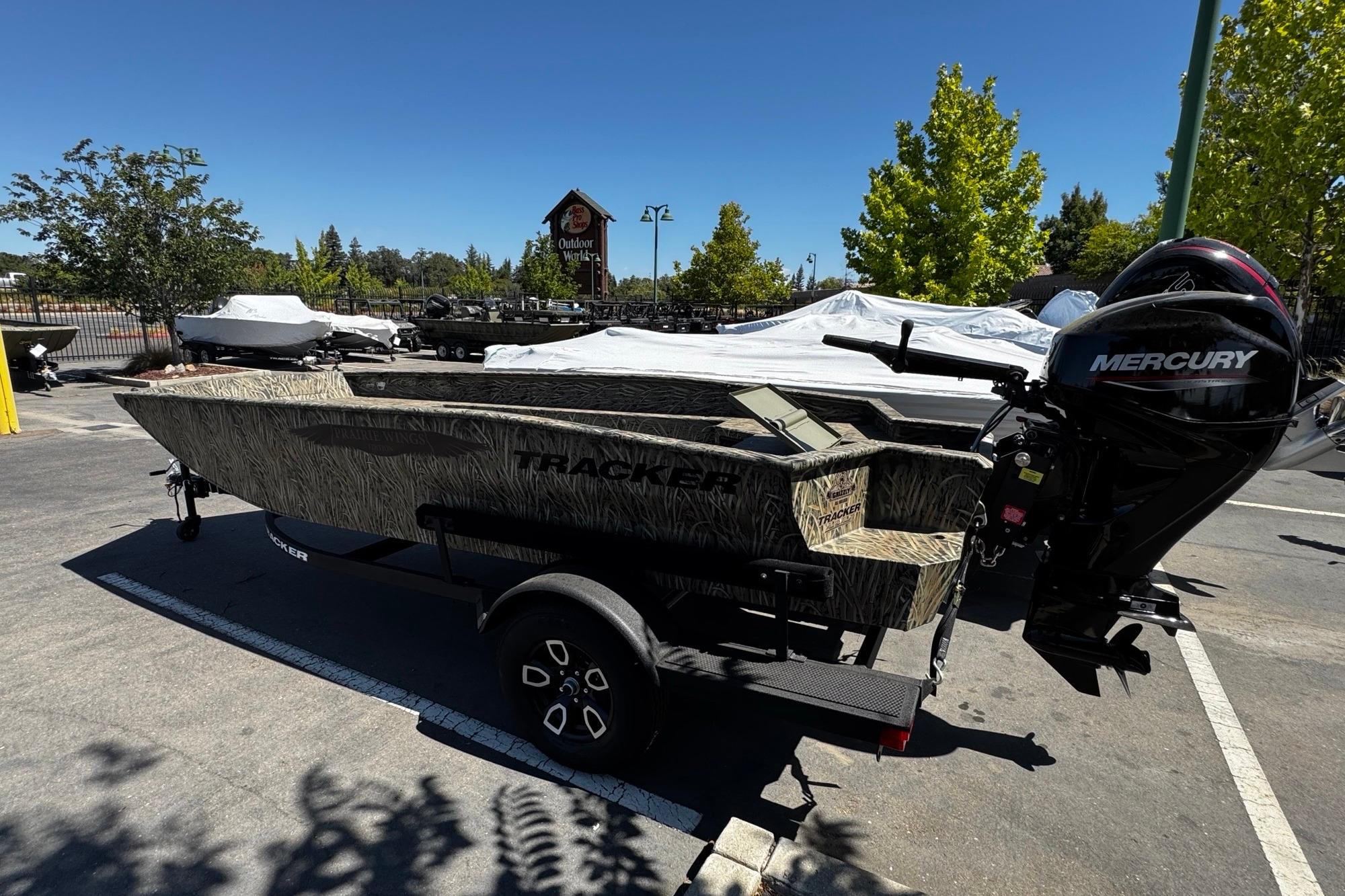 2026 Tracker Grizzly 1650 T Prairie Wings Edition boat with Mercury engine in parking lot.