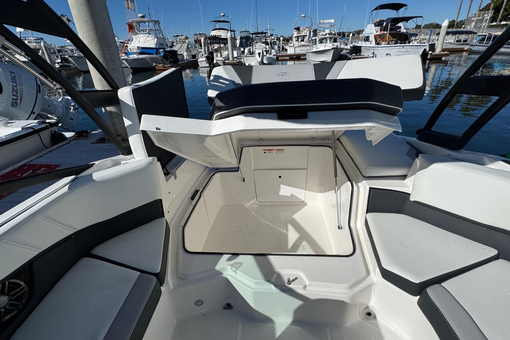 2026 Regal 21 OBX boat interior with seating and storage, docked at a marina.