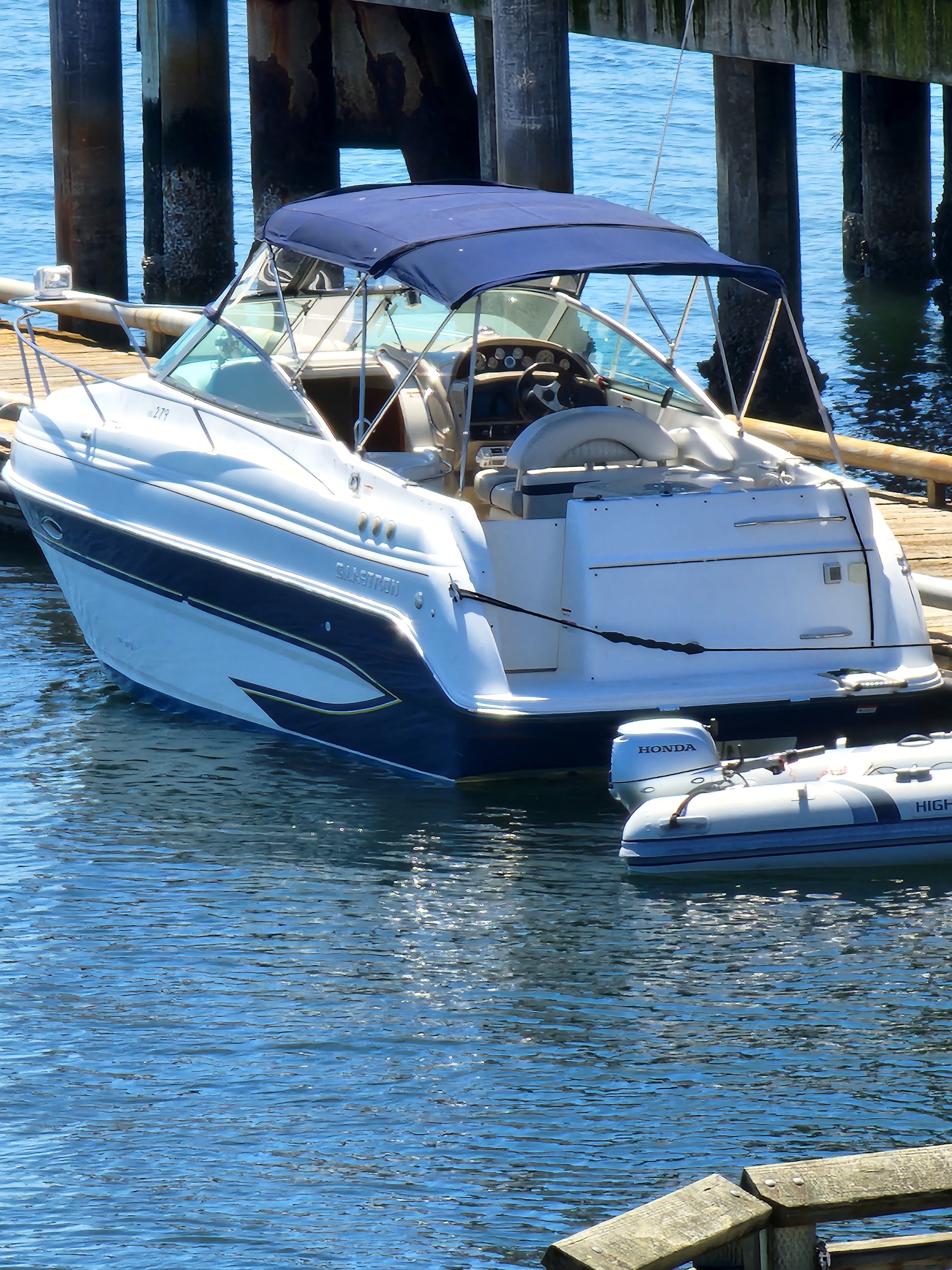 2006 Glastron GS boat docked with inflatable dinghy.