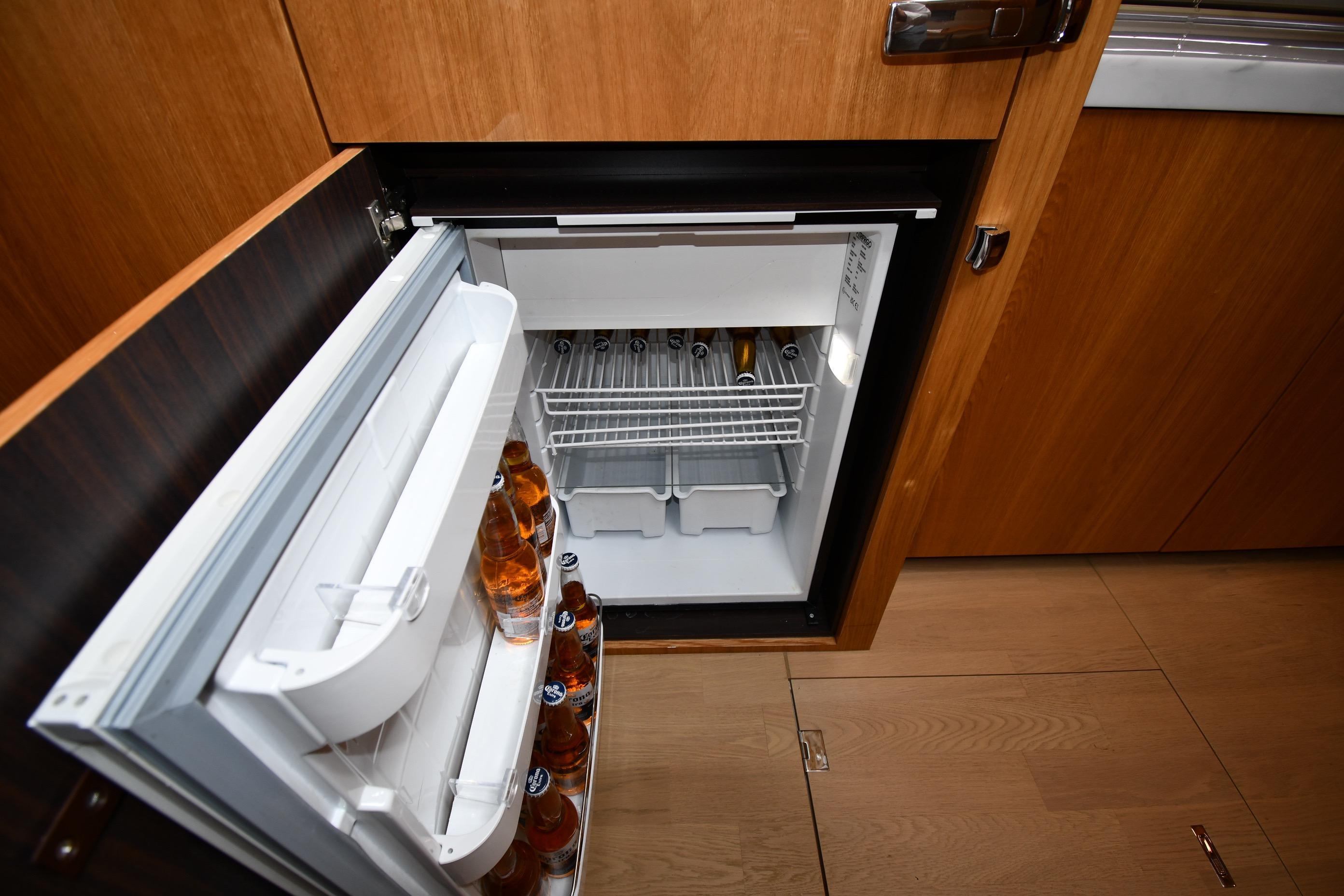 Open fridge in 2024 Fairline G50 Targa yacht, stocked with beverages.