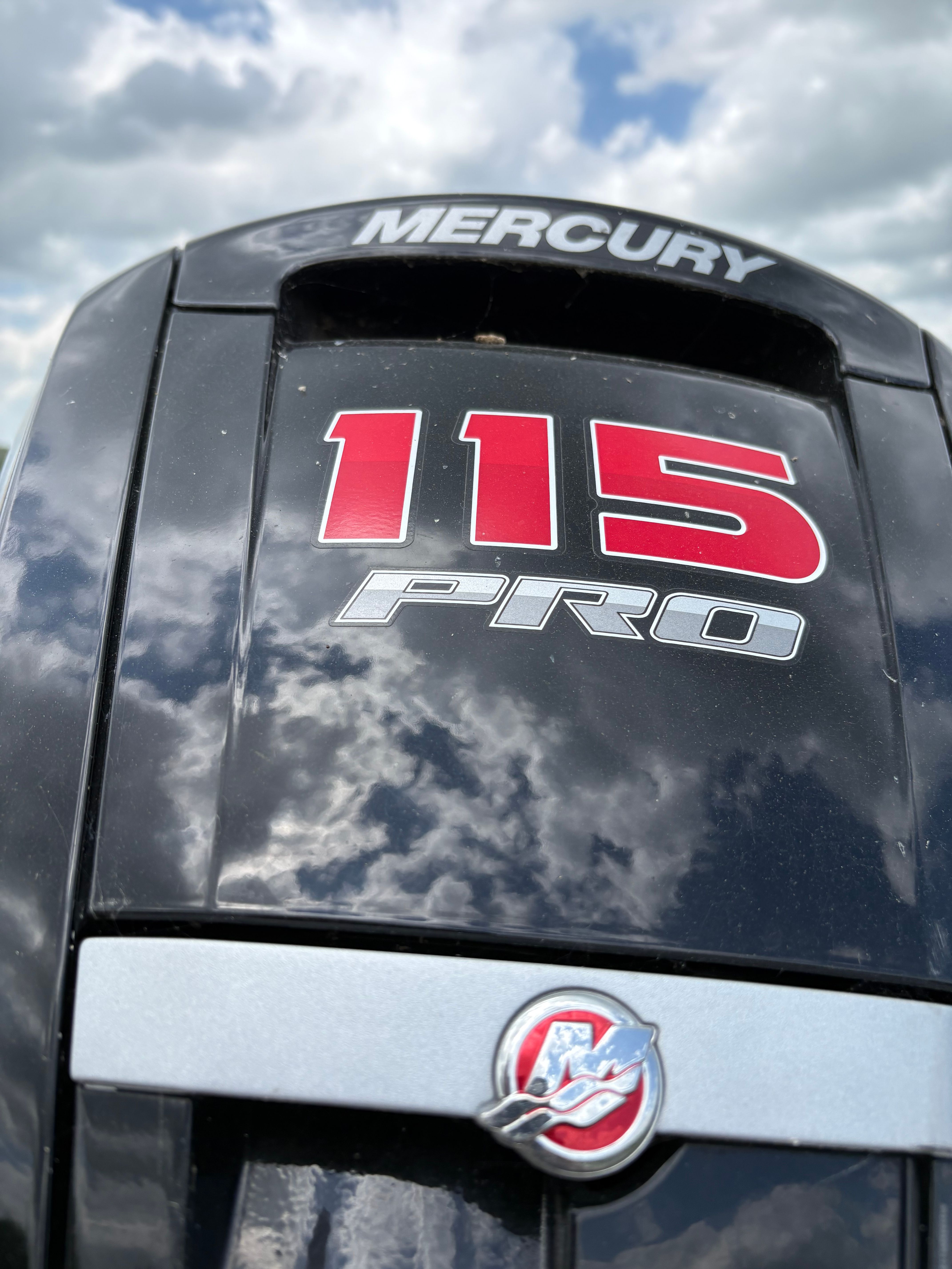 Mercury 115 Pro outboard motor reflecting clouds.