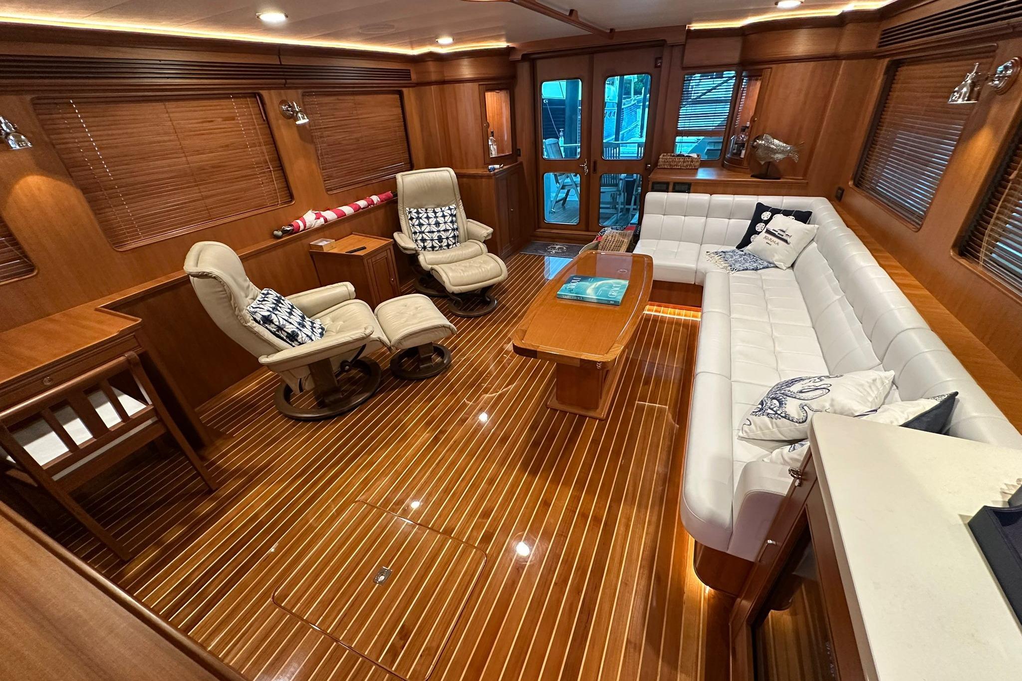 Luxurious interior of 2023 Marlow Explorer 66E-CB yacht with elegant wood finishes and plush seating.