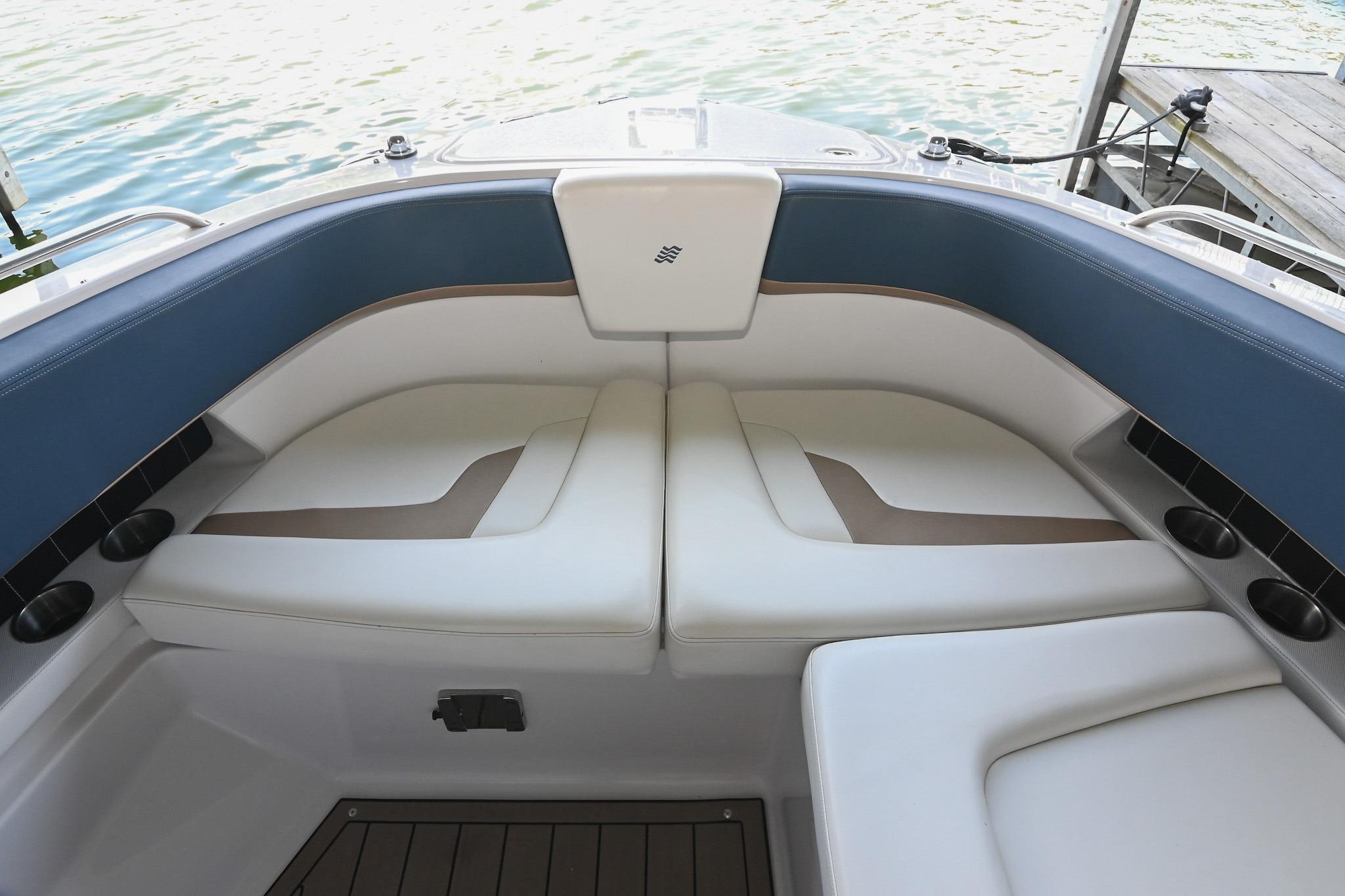 Interior seating of 2014 Four Winns H290 boat, featuring white and blue cushioned seats.