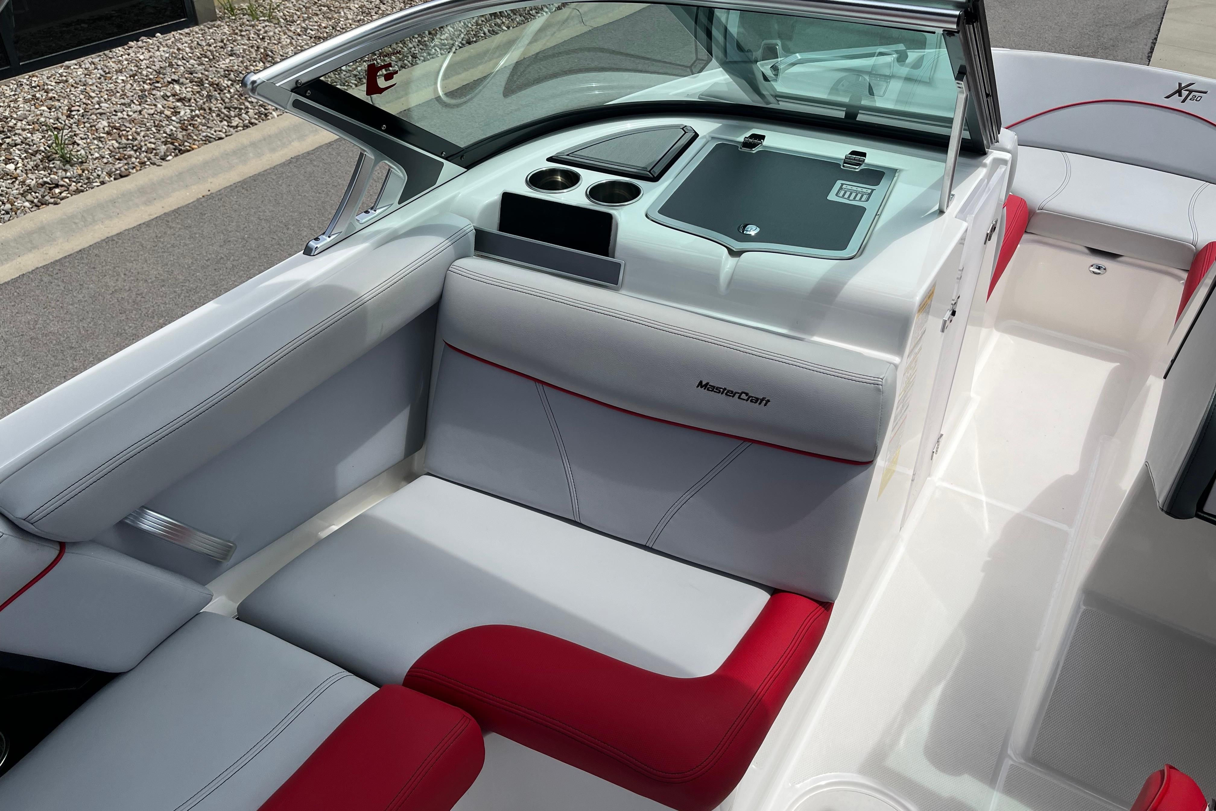 2019 MasterCraft XT20 boat interior with red and white seating, cup holders, and dashboard.