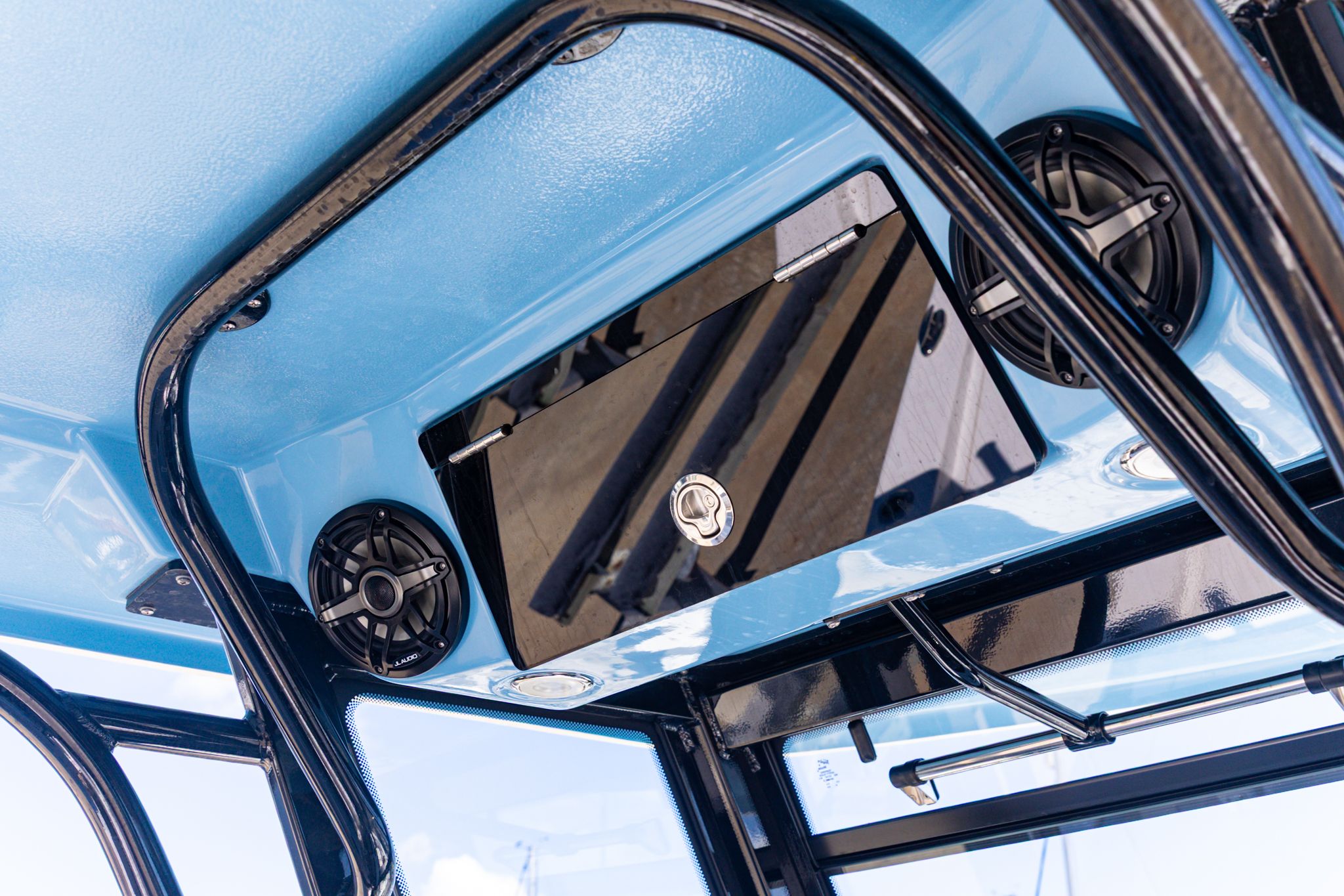 Robalo 266 Cayman 2026: Blue ceiling with speakers and storage compartment.