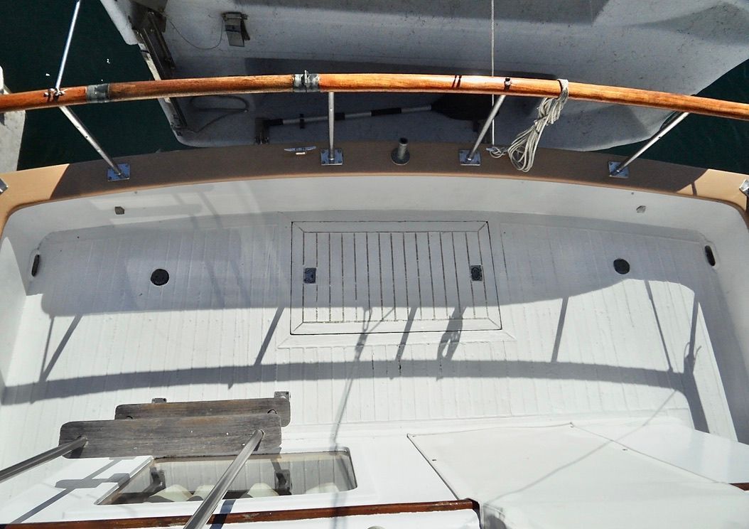 1976 CHB Trawler deck with wooden railings and hatch, viewed from above.