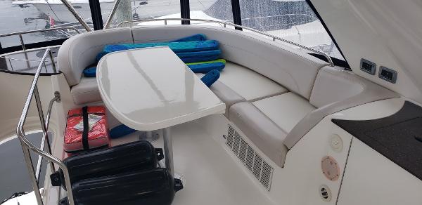 2010 Meridian 441 Sedan yacht interior with cushioned seating and table.