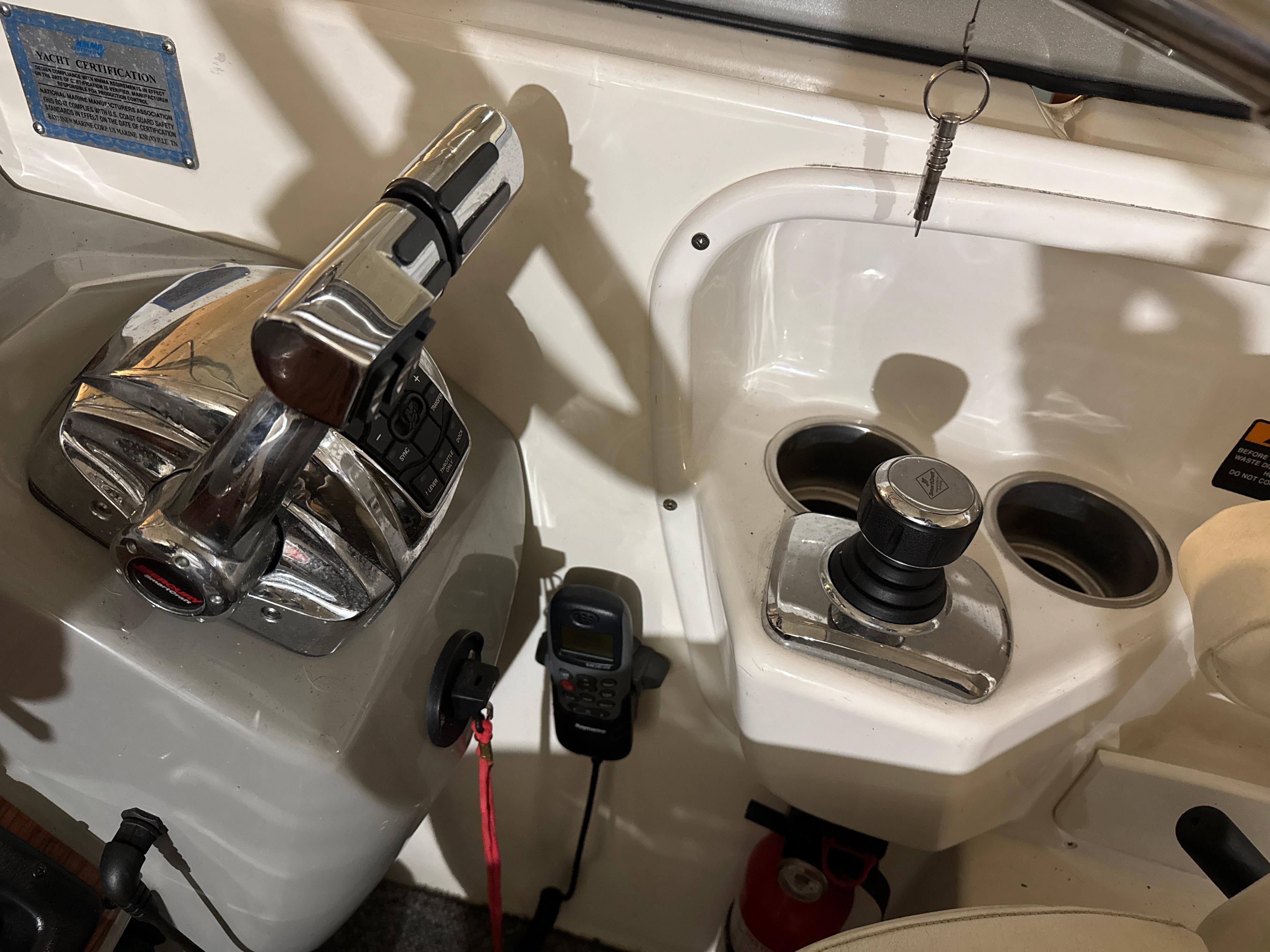 Control panel of a 2009 Bayliner 300 boat with throttle and cup holders.