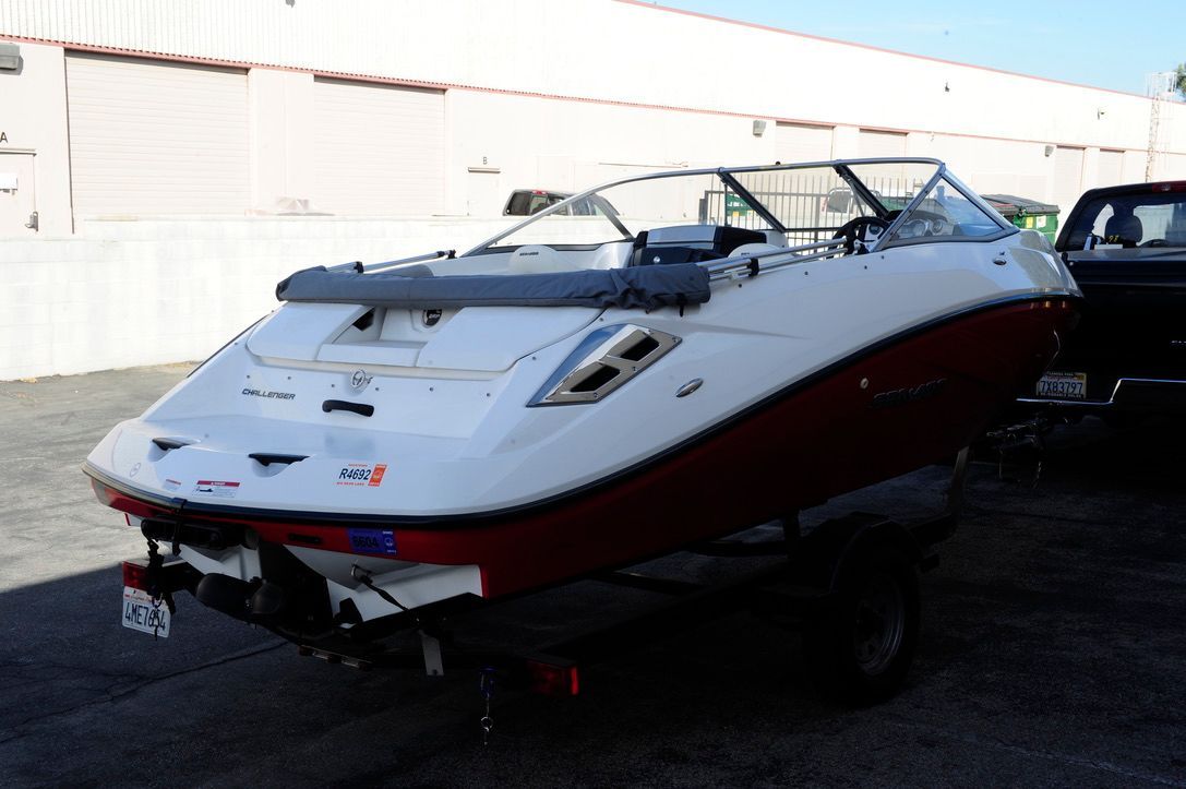 A white and red motorboat on a trailer in a storage area.