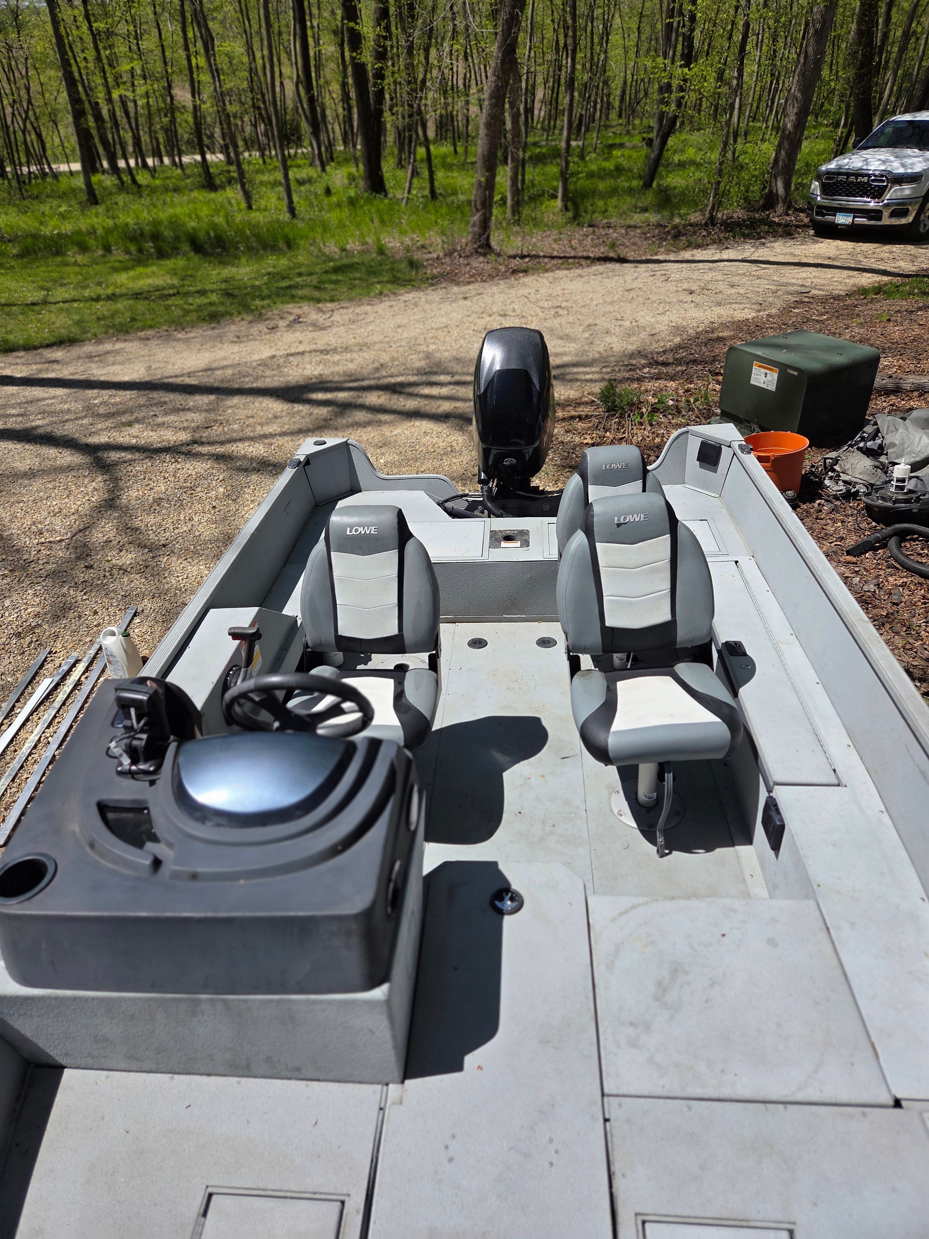 2015 Lowe Fishing Machine 165 Poly Camo boat parked in wooded area.