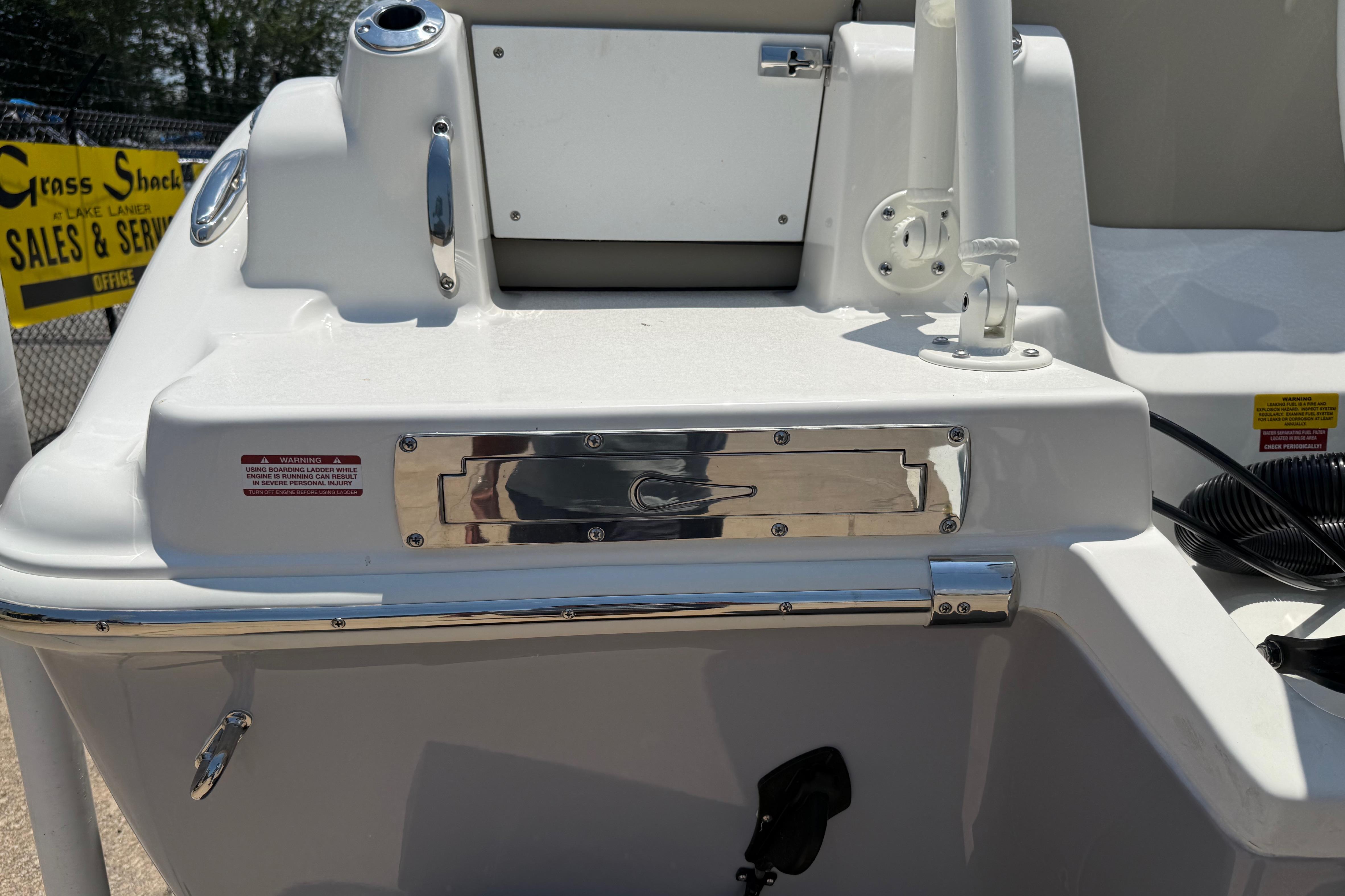 2027 Key West 249 FS boat stern with ladder and warning label.