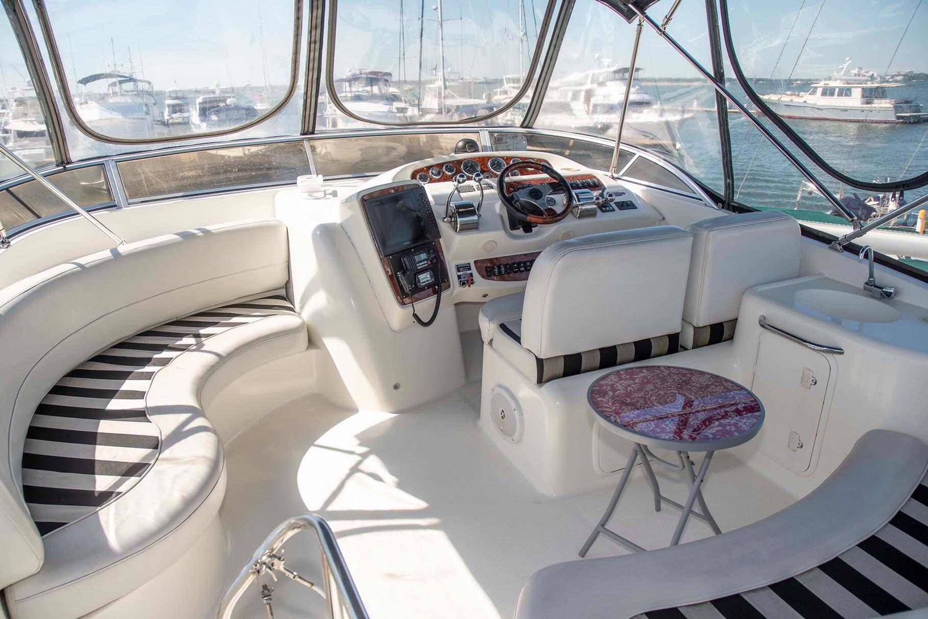 Luxurious 2006 Meridian 411 Sedan yacht interior with striped seating and helm.