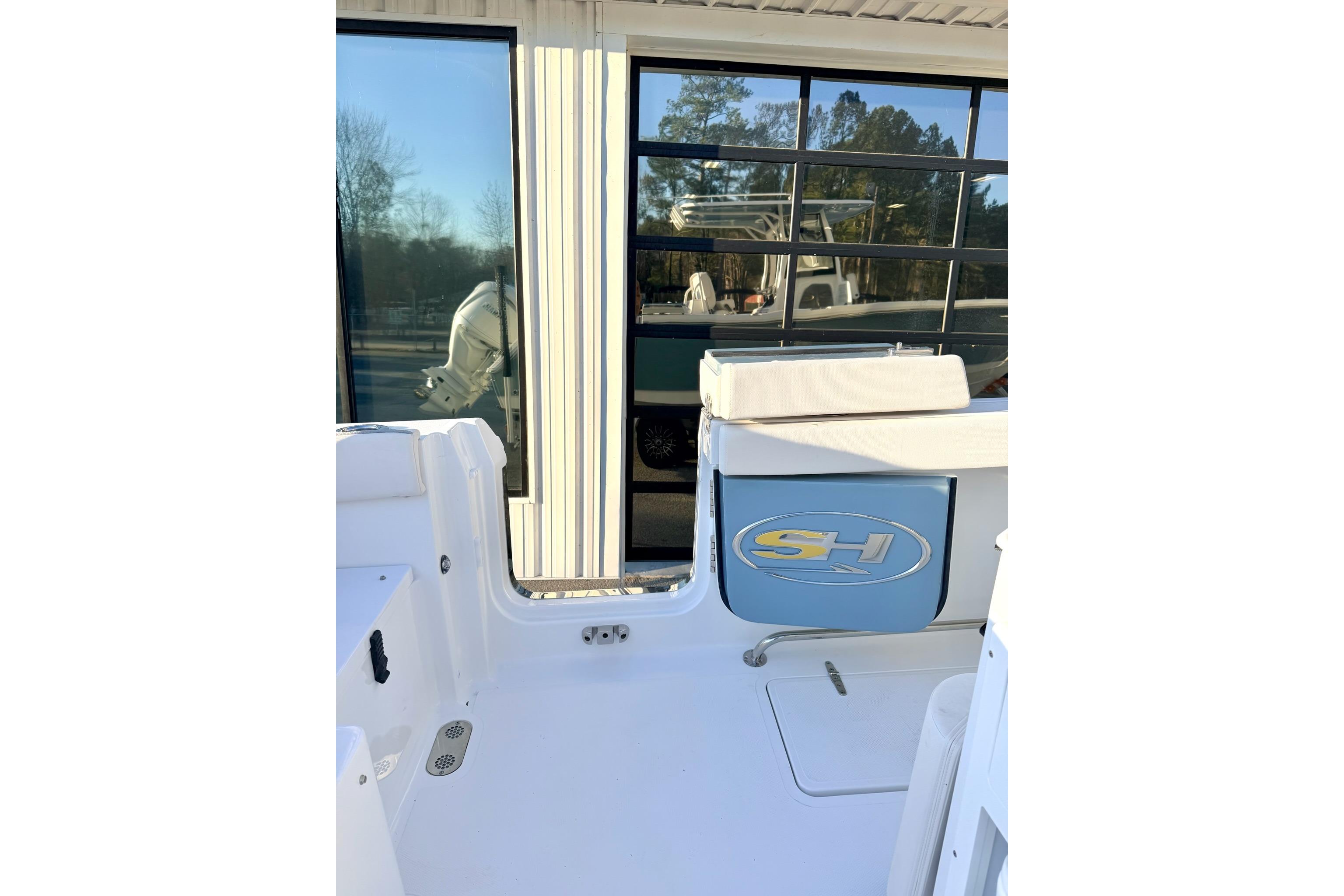 2026 Sea Hunt Ultra 275 Coffin Box boat interior with logo, reflecting in window.