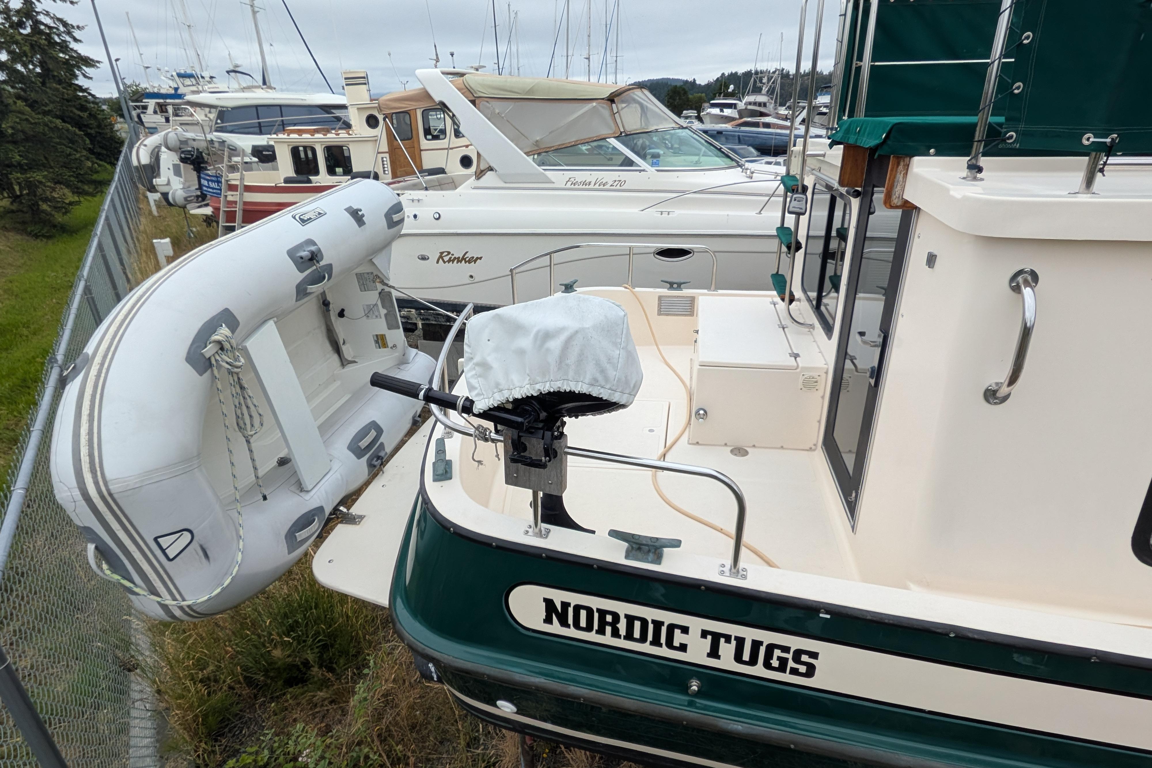 1998 Nordic Tug 32 docked with inflatable dinghy attached at the stern.