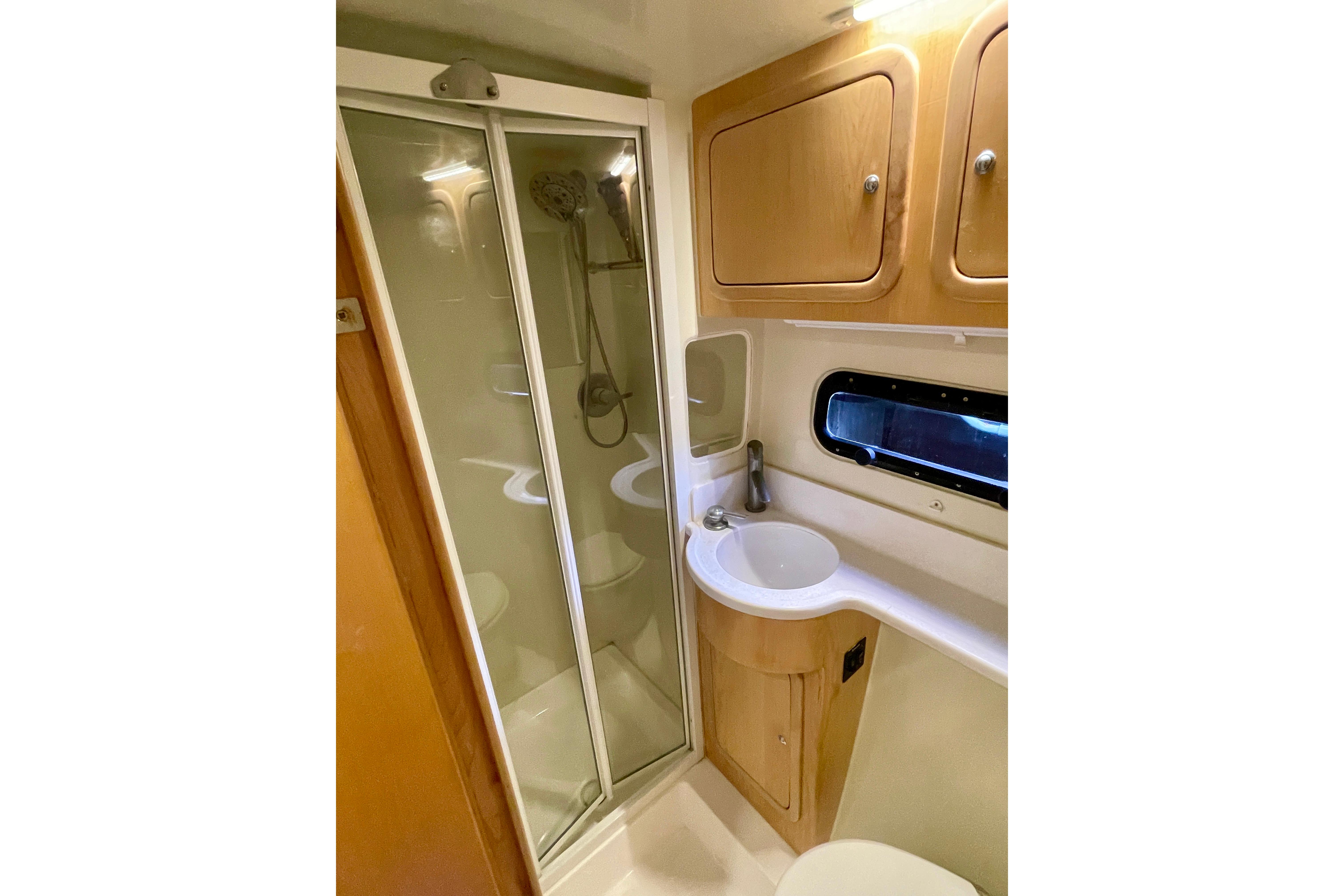Compact bathroom in 2017 St Francis 50 MK 2 yacht with shower, sink, and storage cabinets.