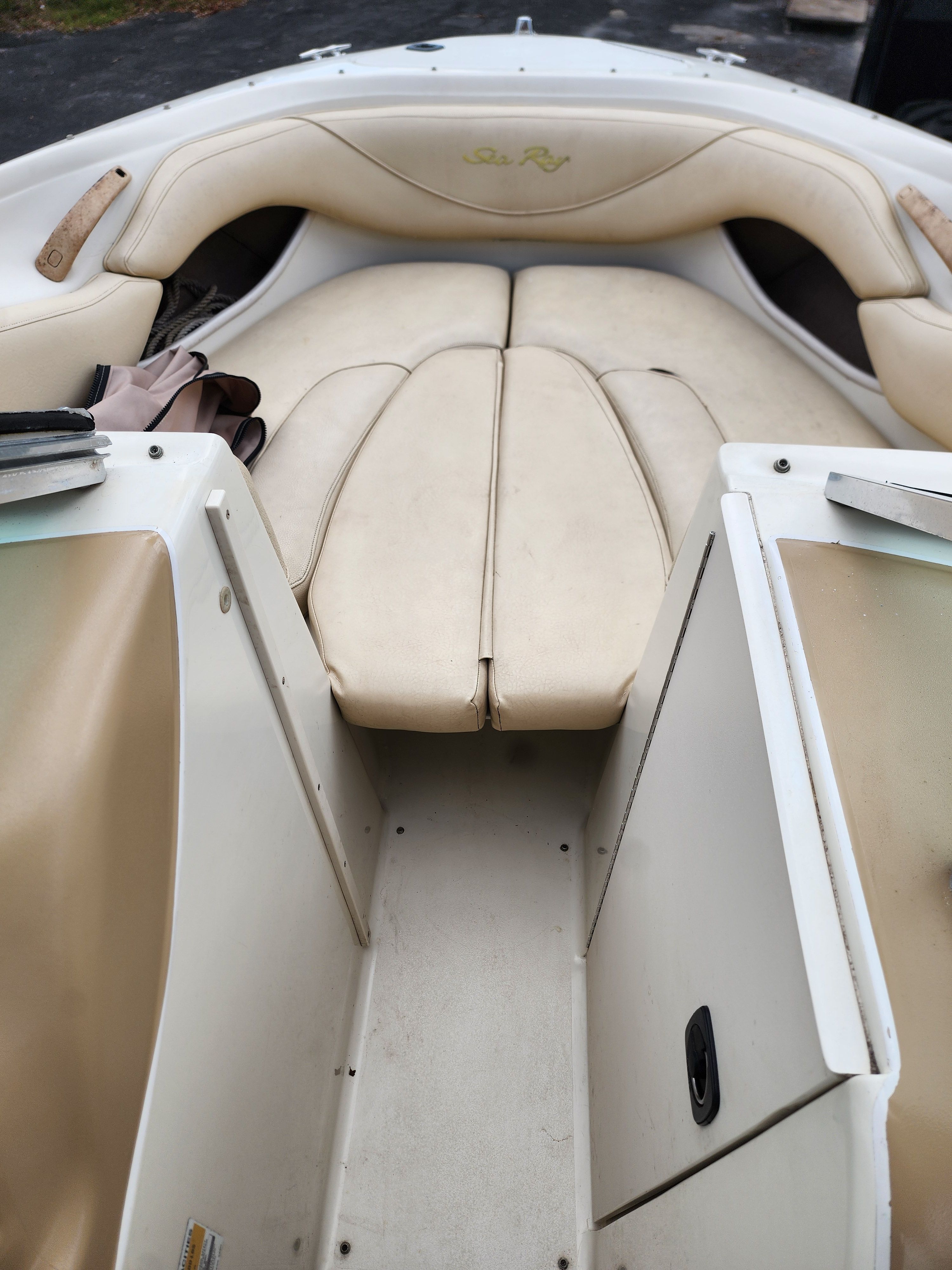 Interior view of a 1999 Sea Ray 210 Bowrider Signature with beige upholstery.