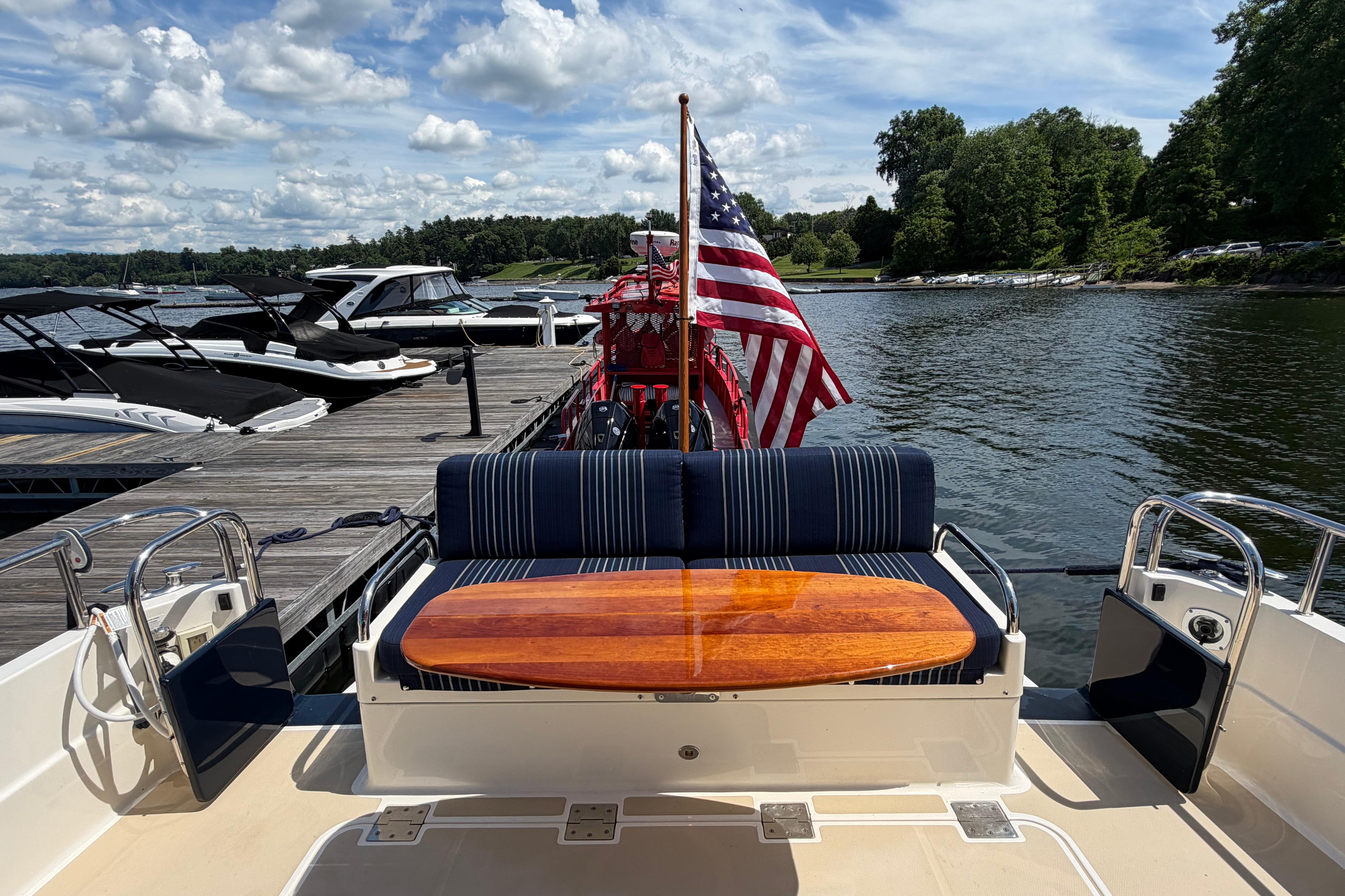 2015 Sabre 38 Salon Express at dock, featuring American flag and scenic lake view.