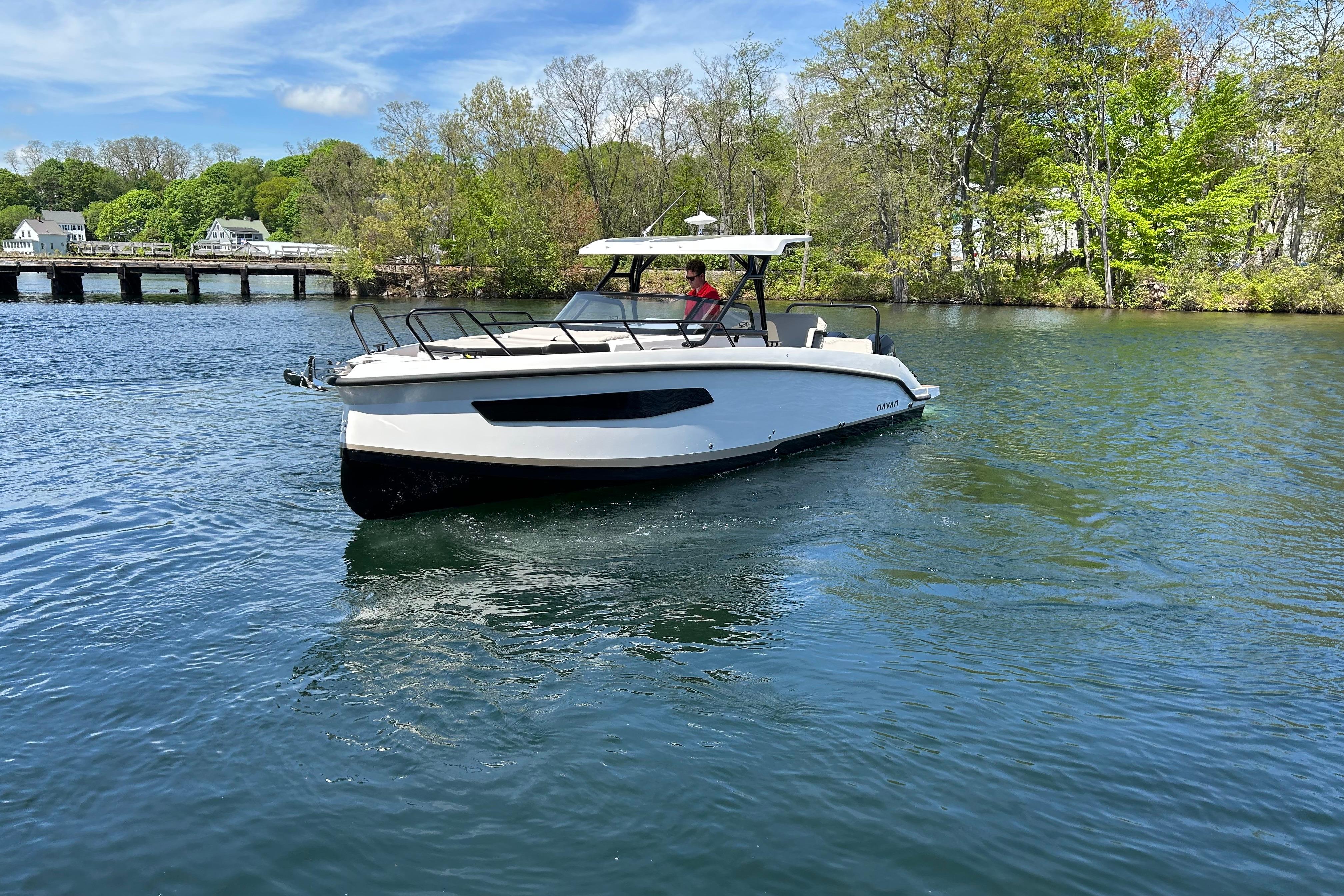 Navan S30 2025 boat cruising on a scenic lake with lush greenery.