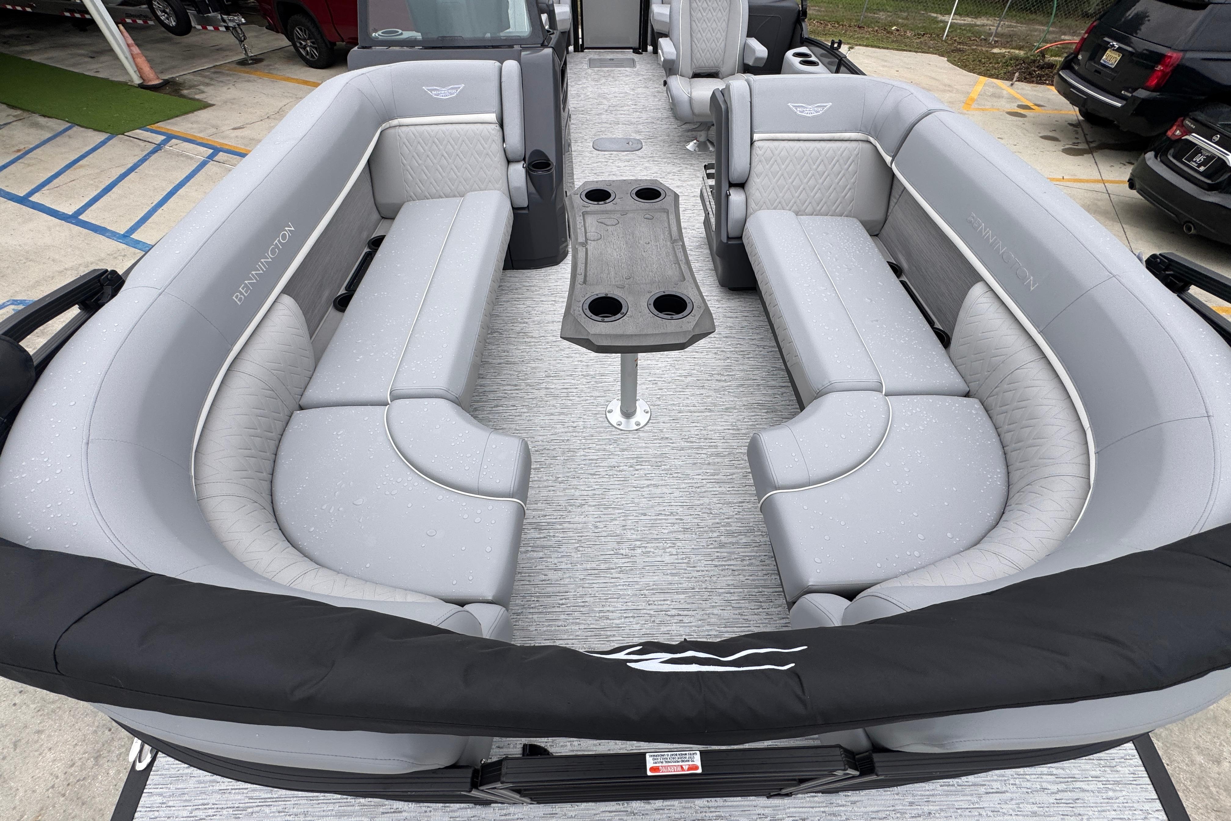 Luxurious interior of 2027 Bennington 24 MFB pontoon boat with gray seating and table.
