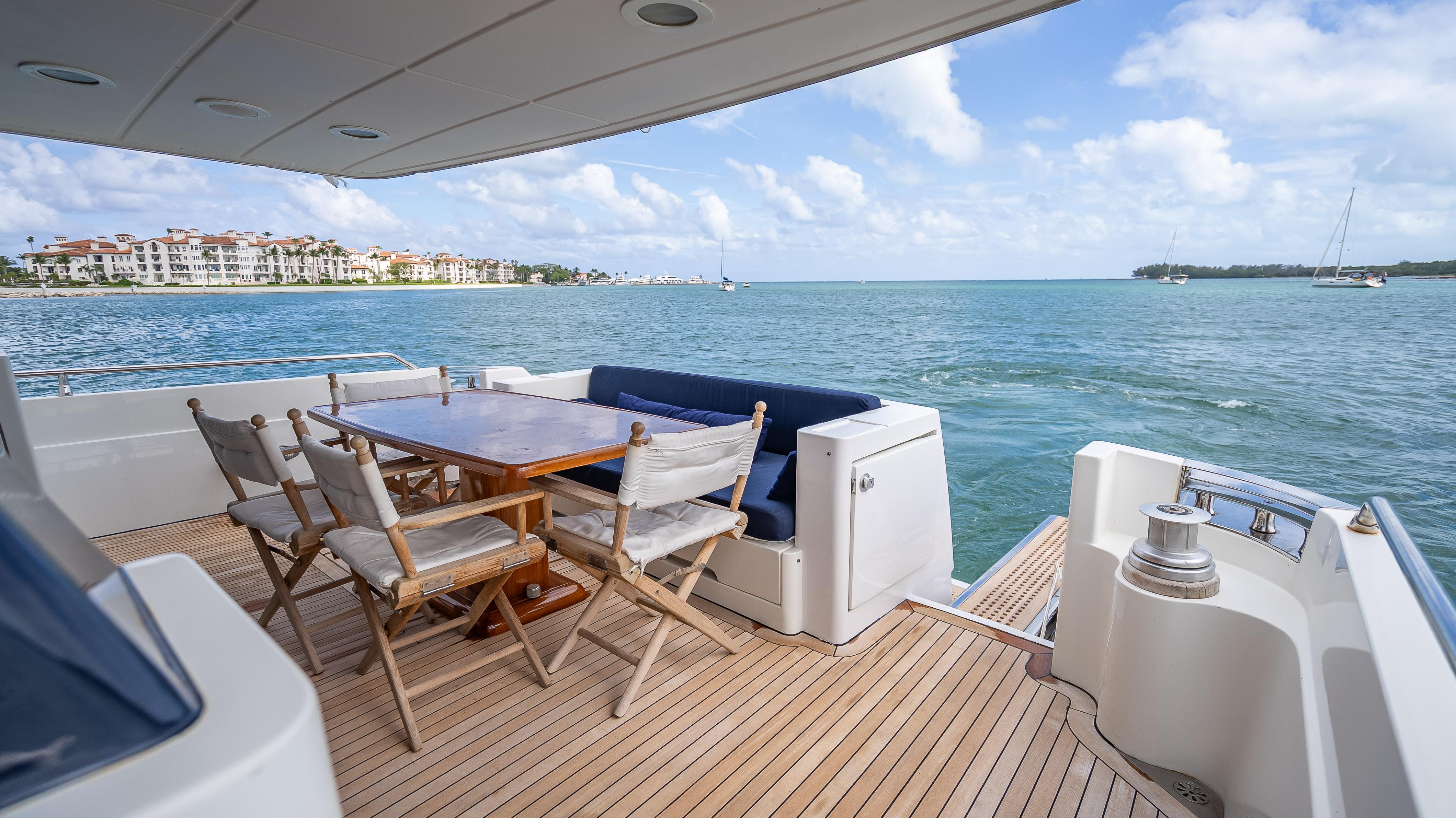 Luxury Sanlorenzo 62 yacht deck with dining area, overlooking serene ocean view, 1995 model.