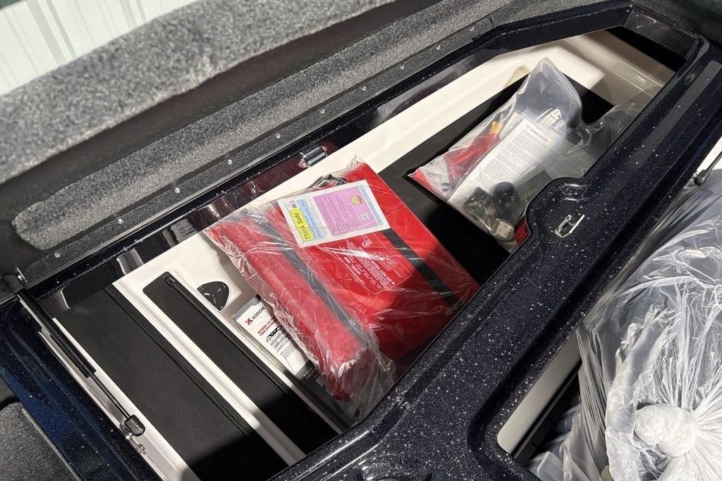 Storage compartment of 2026 Skeeter ZXE21 boat with safety equipment and accessories.