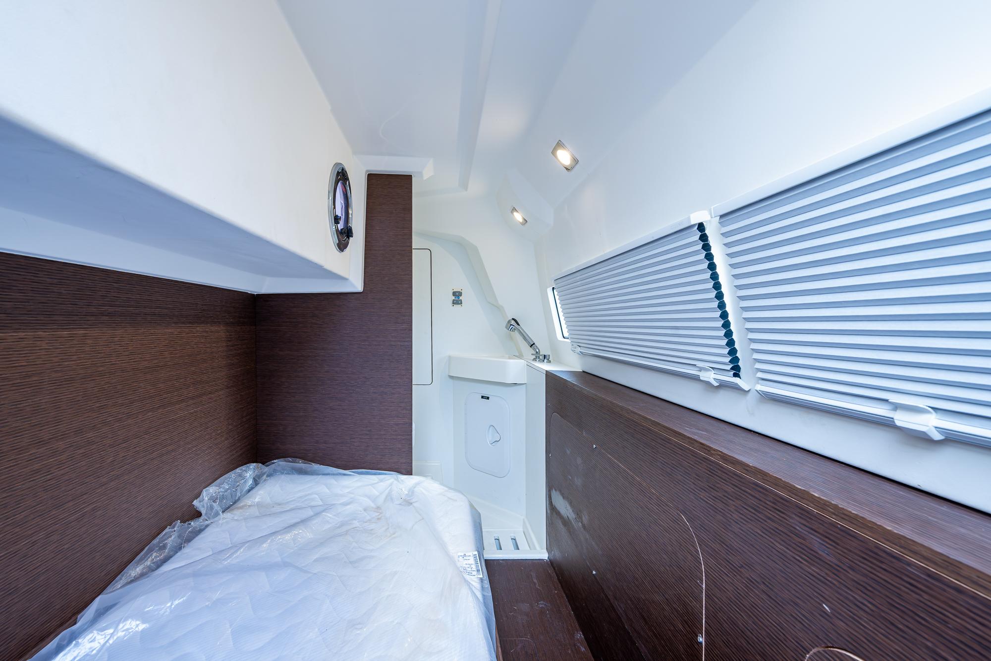 Interior cabin of 2019 Prestige 460 yacht with bed and window blinds.
