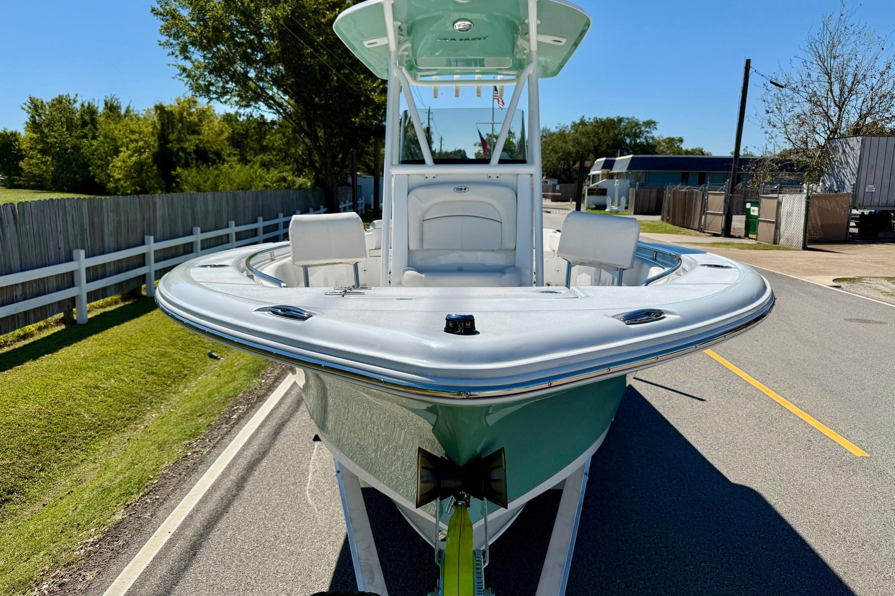 2026 Sea Hunt Ultra 229 boat on trailer, parked on a sunny street.
