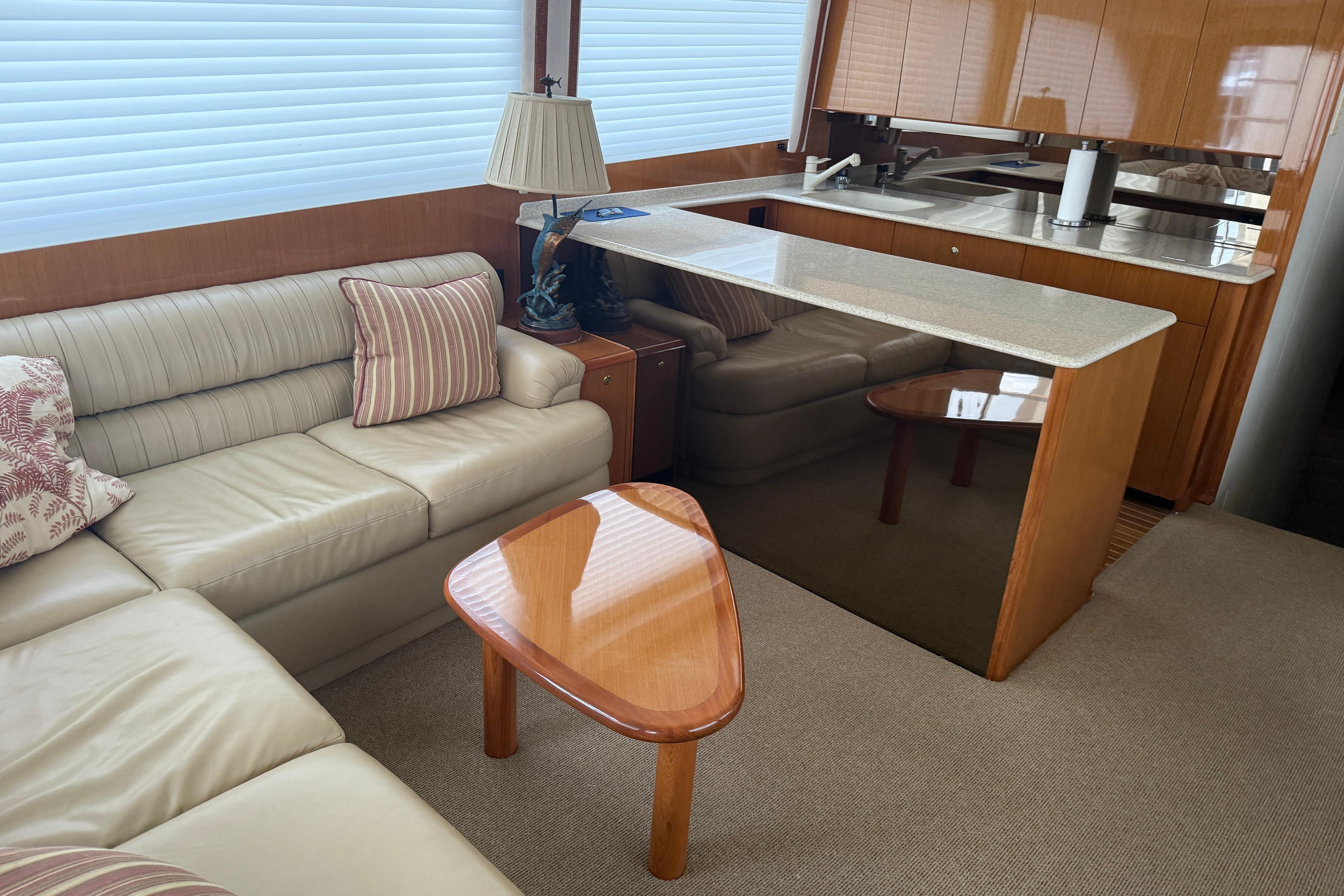 Luxurious interior of a 2000 Viking 55 Convertible yacht with elegant seating and modern kitchen.