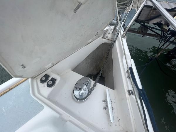 An open anchor locker on a boat with chain and windlass visible.