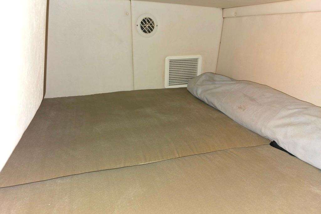 2006 Sea Ray 240 Sundancer cabin interior with beige bedding and ventilation.