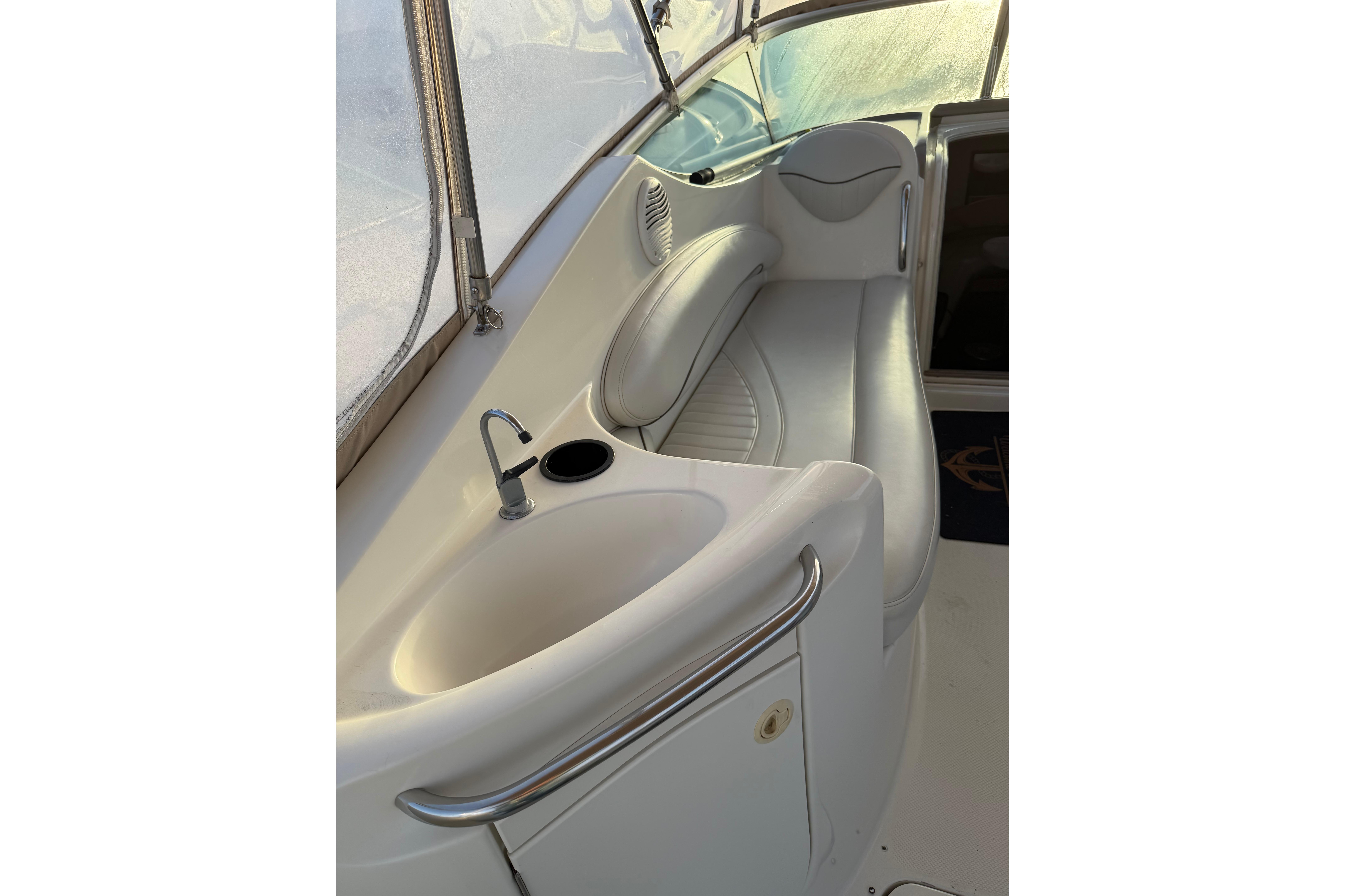 2001 Maxum 2800 SCR boat interior with sink and seating area.