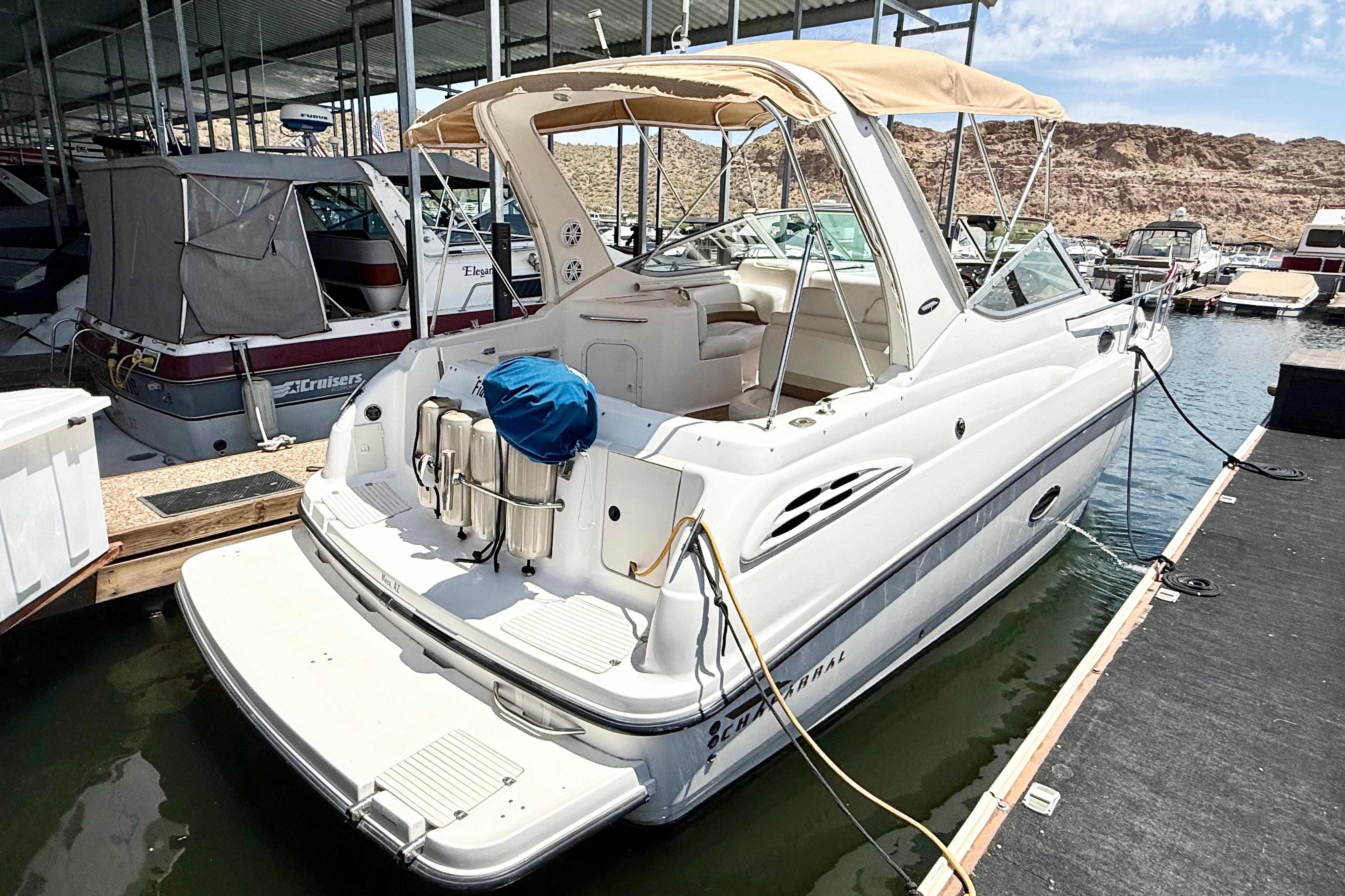 1999 Chaparral Signature 300 boat docked at marina, featuring spacious deck and canopy.