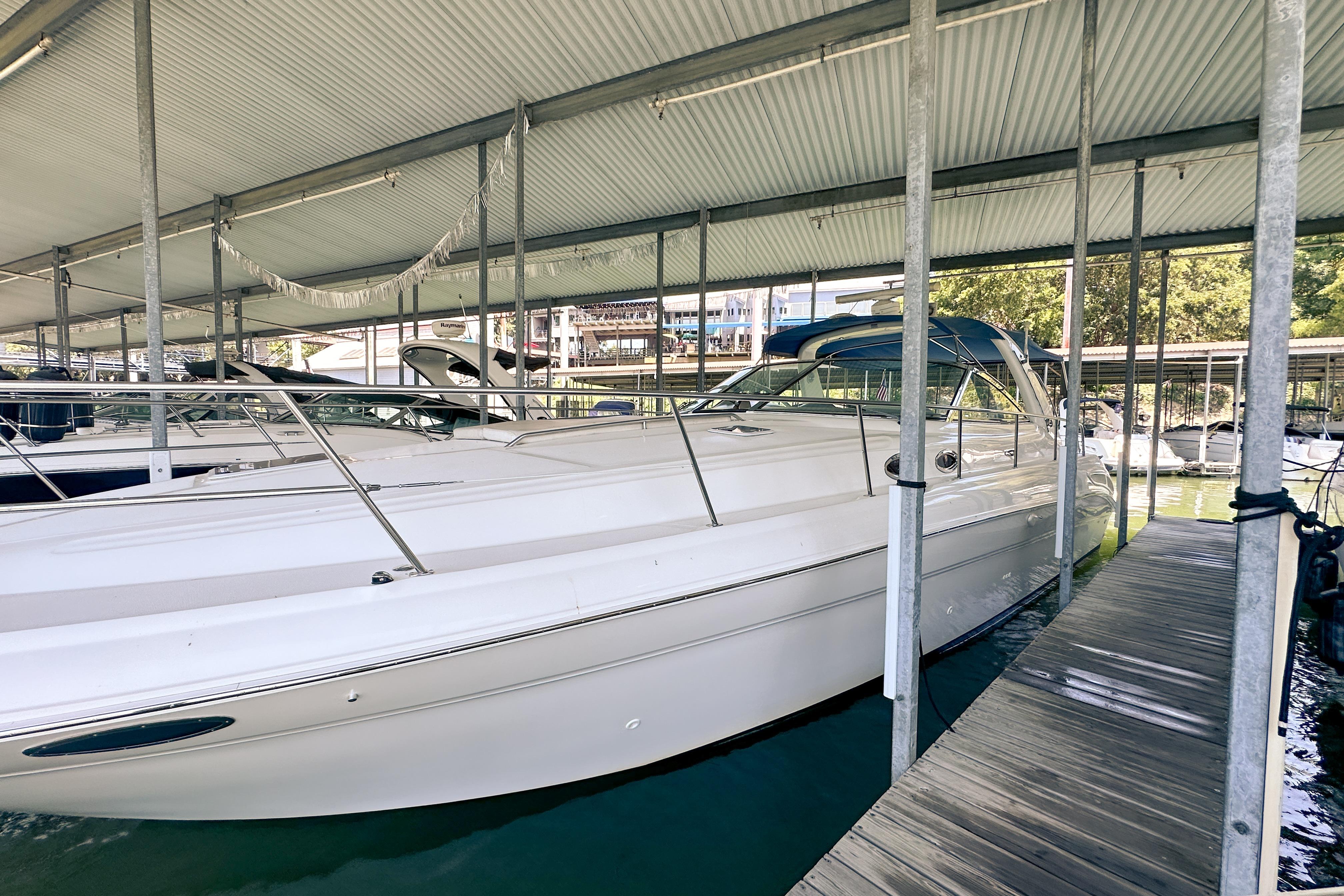 2001 Sea Ray 410 Sundancer docked under a covered marina.
