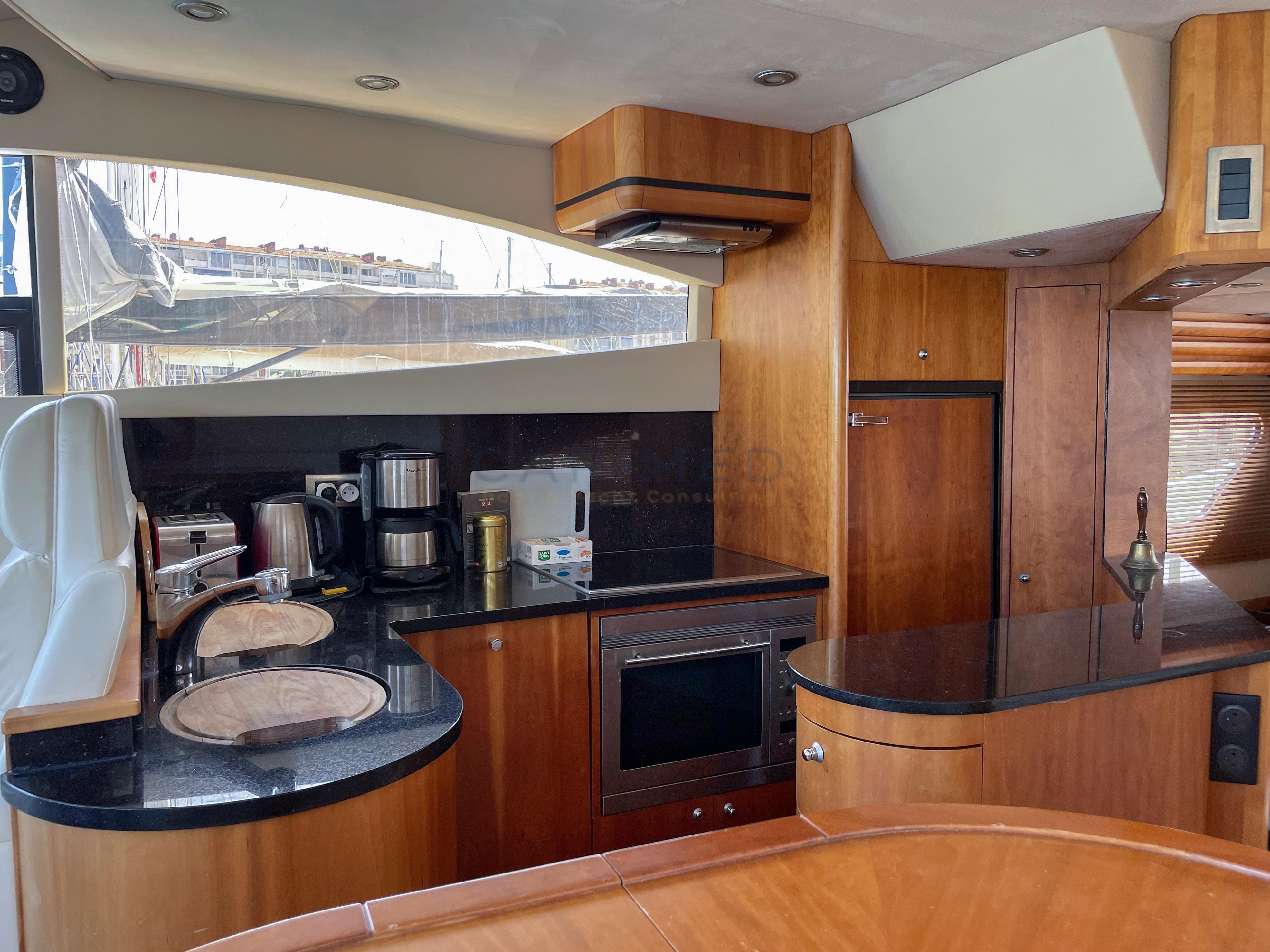 Luxurious yacht kitchen interior with modern appliances, wooden cabinetry, and sleek countertops, Pearl 60, 2006.