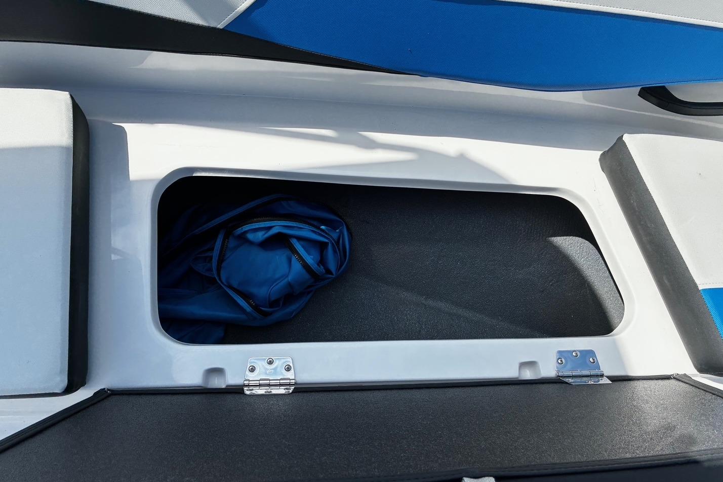Storage compartment in 2026 Starcraft SV 16 OB boat, featuring blue fabric inside.