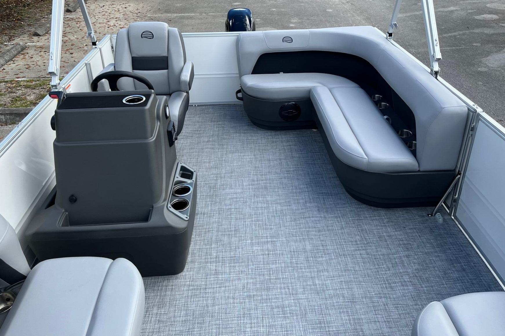2026 Sun Tracker Party Barge 16 DLX interior with gray seating and steering console.